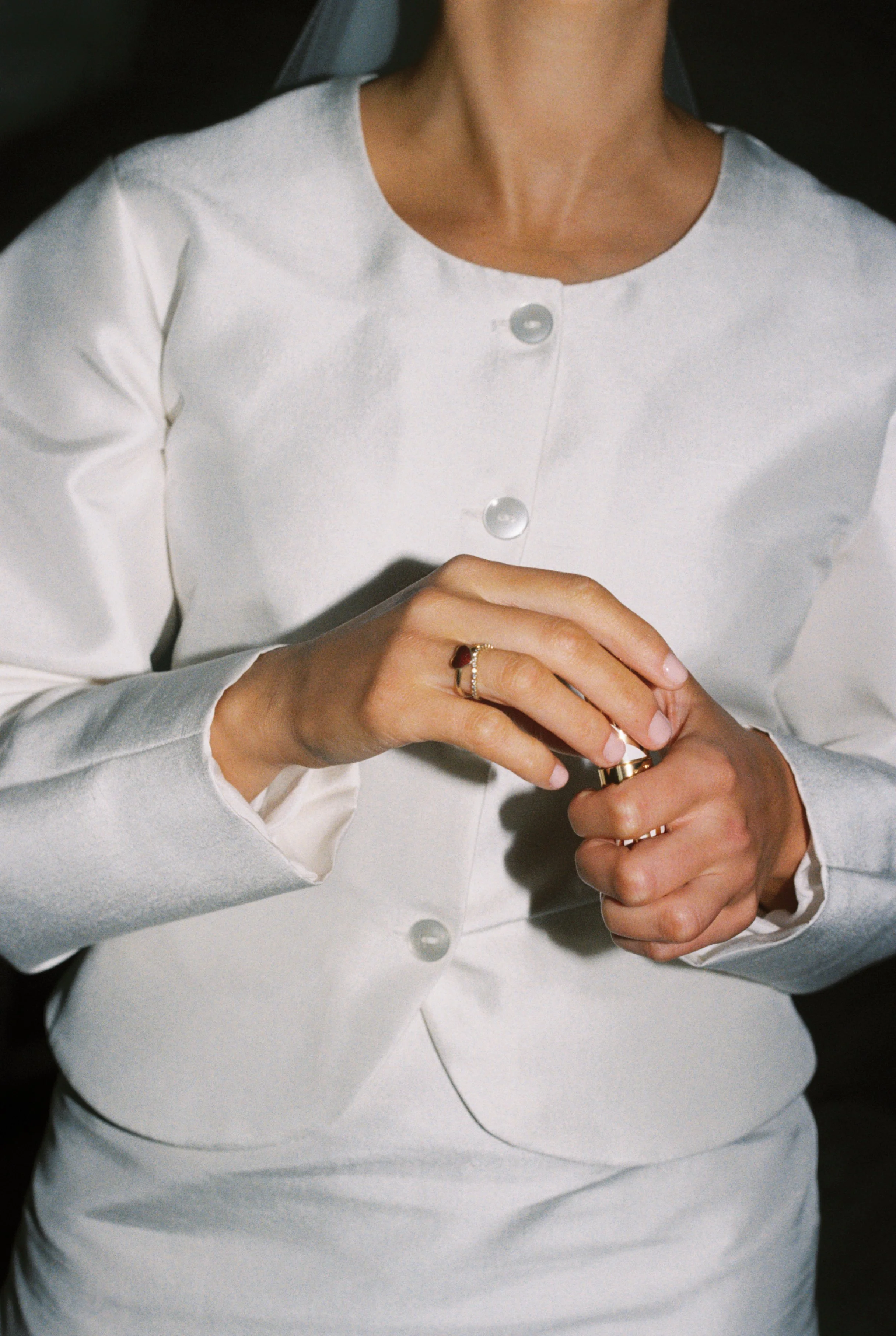 Close-up of silk bridal garment, emphasizing fabric texture, finishing details, and refined tailoring.