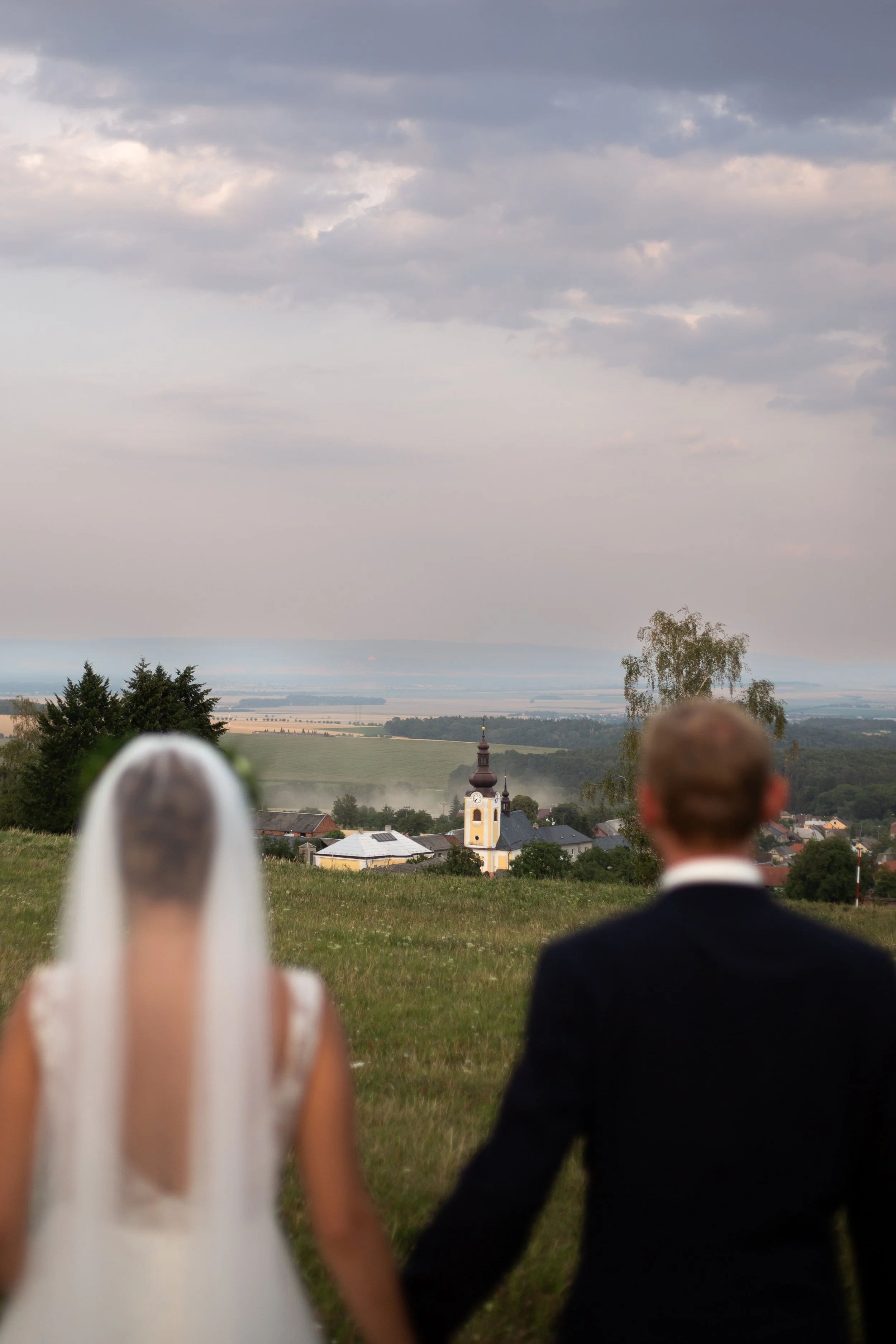 Laurie’s customers, Mariana and Carmen holding hands on a green lawn on their wedding day.
