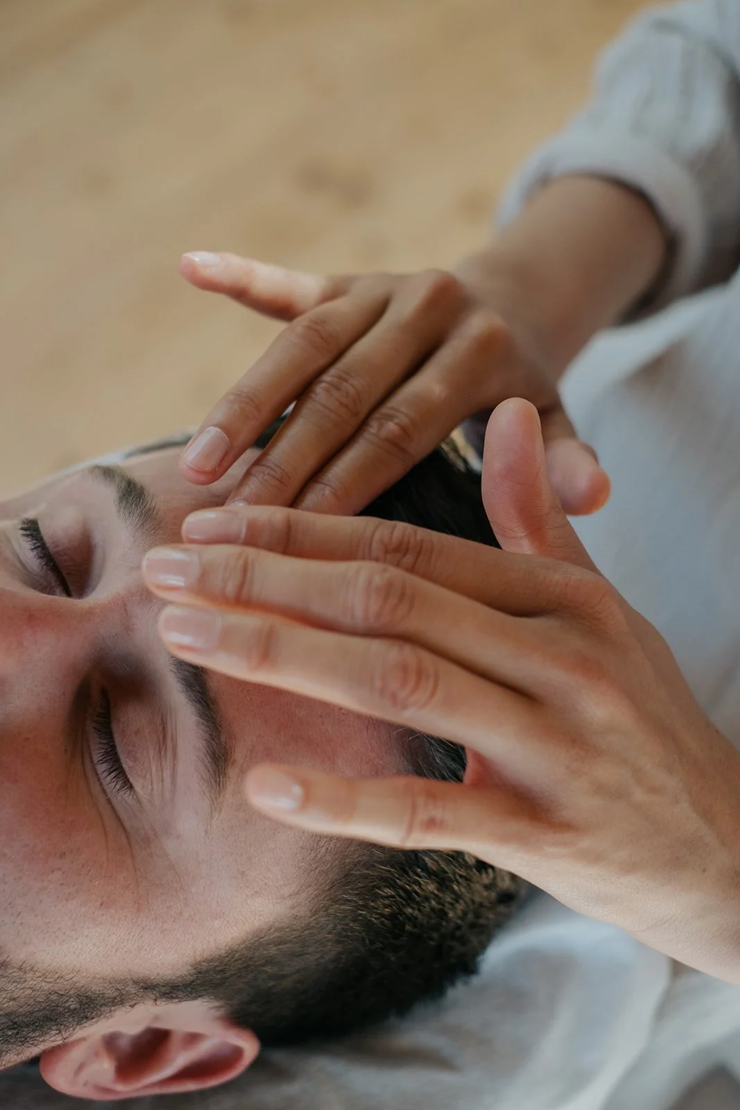 Person erhält eine Gesichtsmassage während sie mit geschlossenen Augen entspannt.