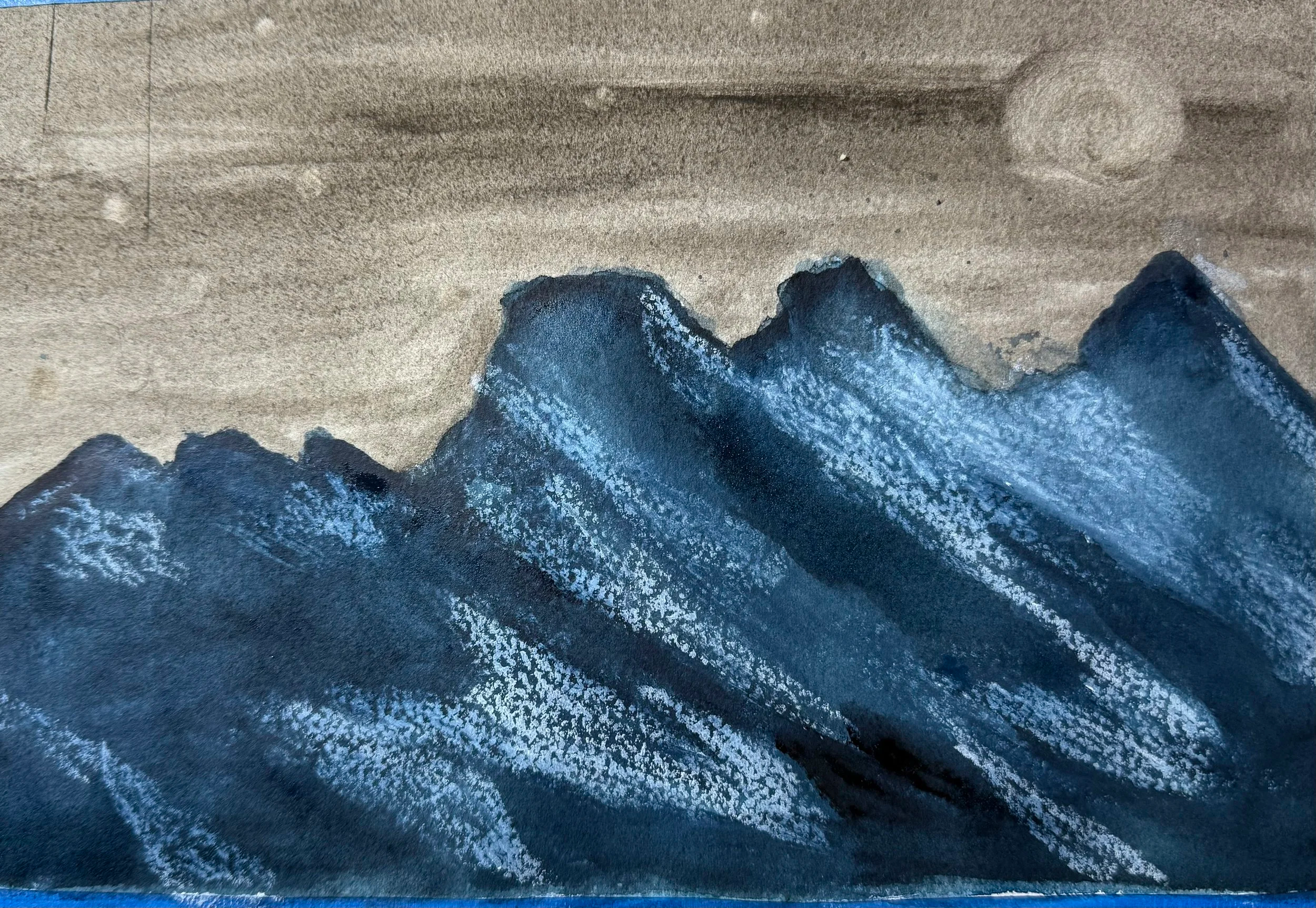 Close-up of a mountain range on a painting or fabric with a dark blue sky and white snow-capped peaks.
