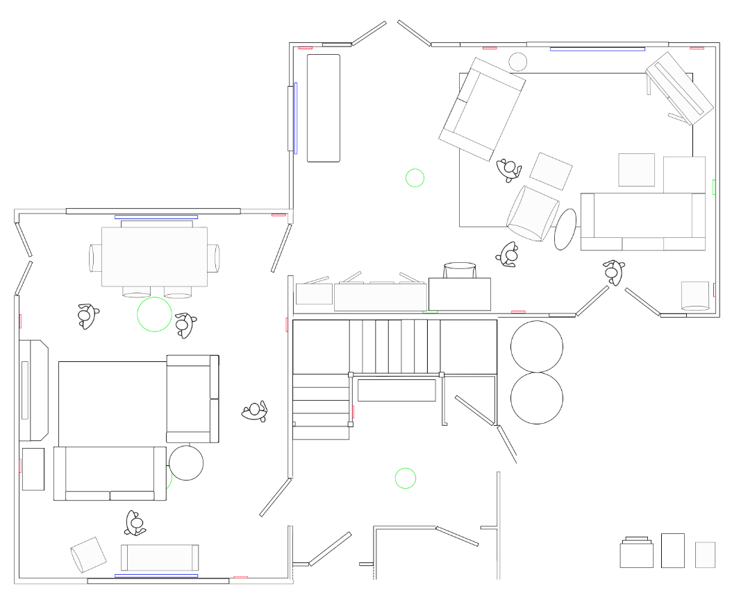 Architectural floor plan showing a two-room layout with furniture, including sofas, chairs, tables, and stairs, along with windows and doors.