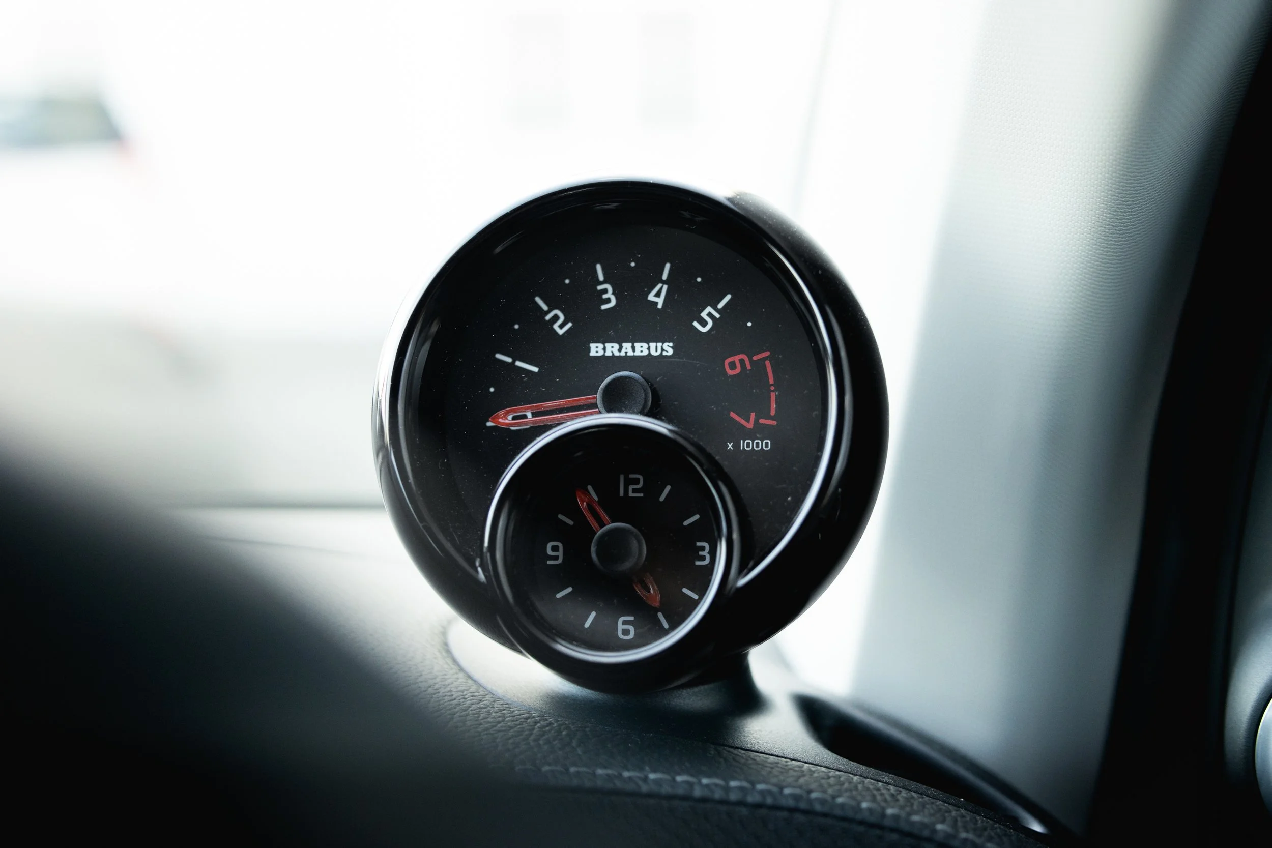 Close-up view of a black Boost gauge with the brand name Brabus, displaying a reading of approximately 1.9, mounted in a vehicle dashboard.