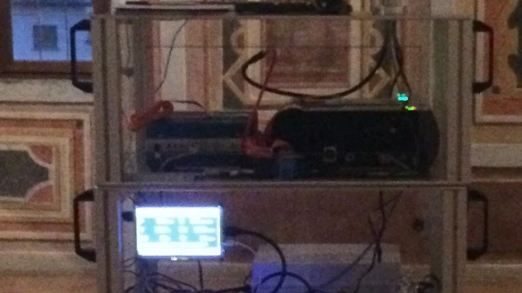 Postazione DJ con due pannelli di controllo e vari cavi, situata in una stanza con pareti decorate.