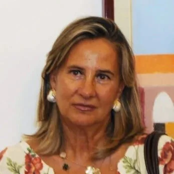 Donna con abbigliamento estivo floreale, orecchini eleganti, sfondo colorato.