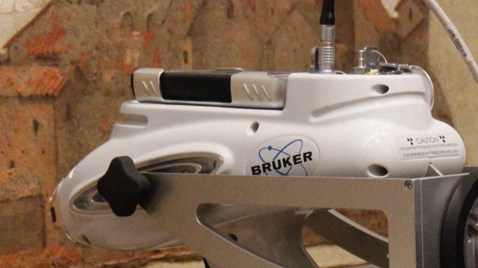 Un ciclocarro con il logo 'BRUKER' contro un muro di mattoni