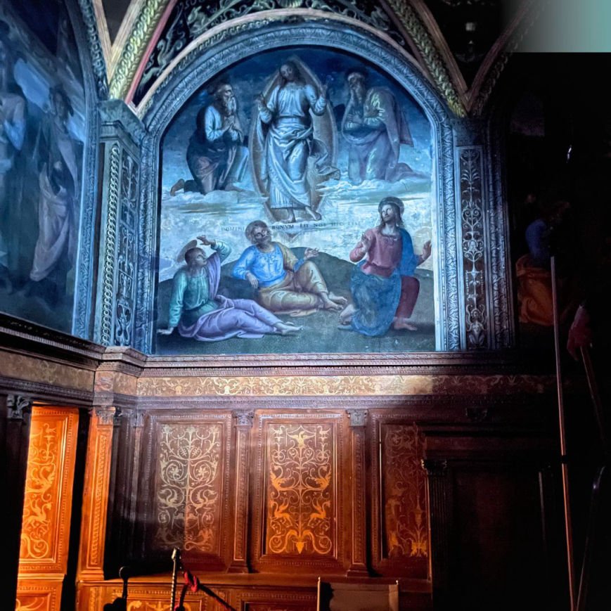 Un dipinto religioso che rappresenta Gesù e altri santi o profeti, con Gesù al centro, in tonalità blu e dorato, all'interno di una chiesa o un capolavoro artistico sacro.