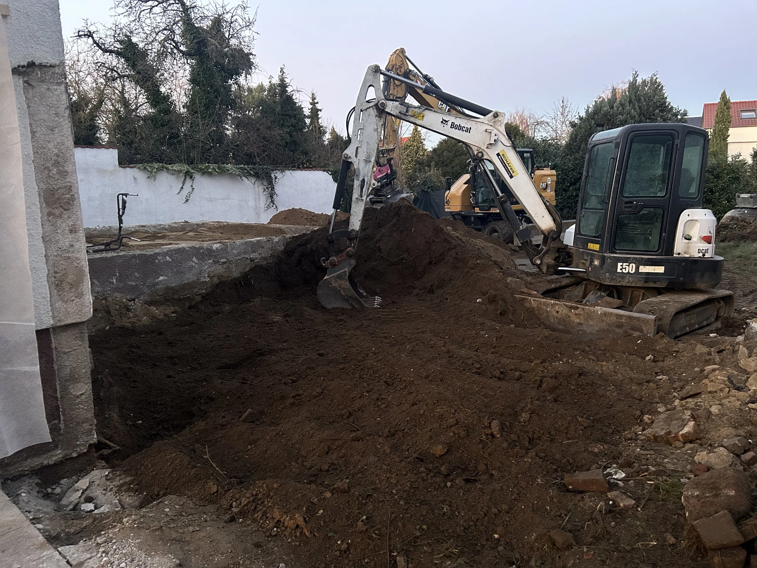 Baustelle mit Bagger, der Erde bewegt.