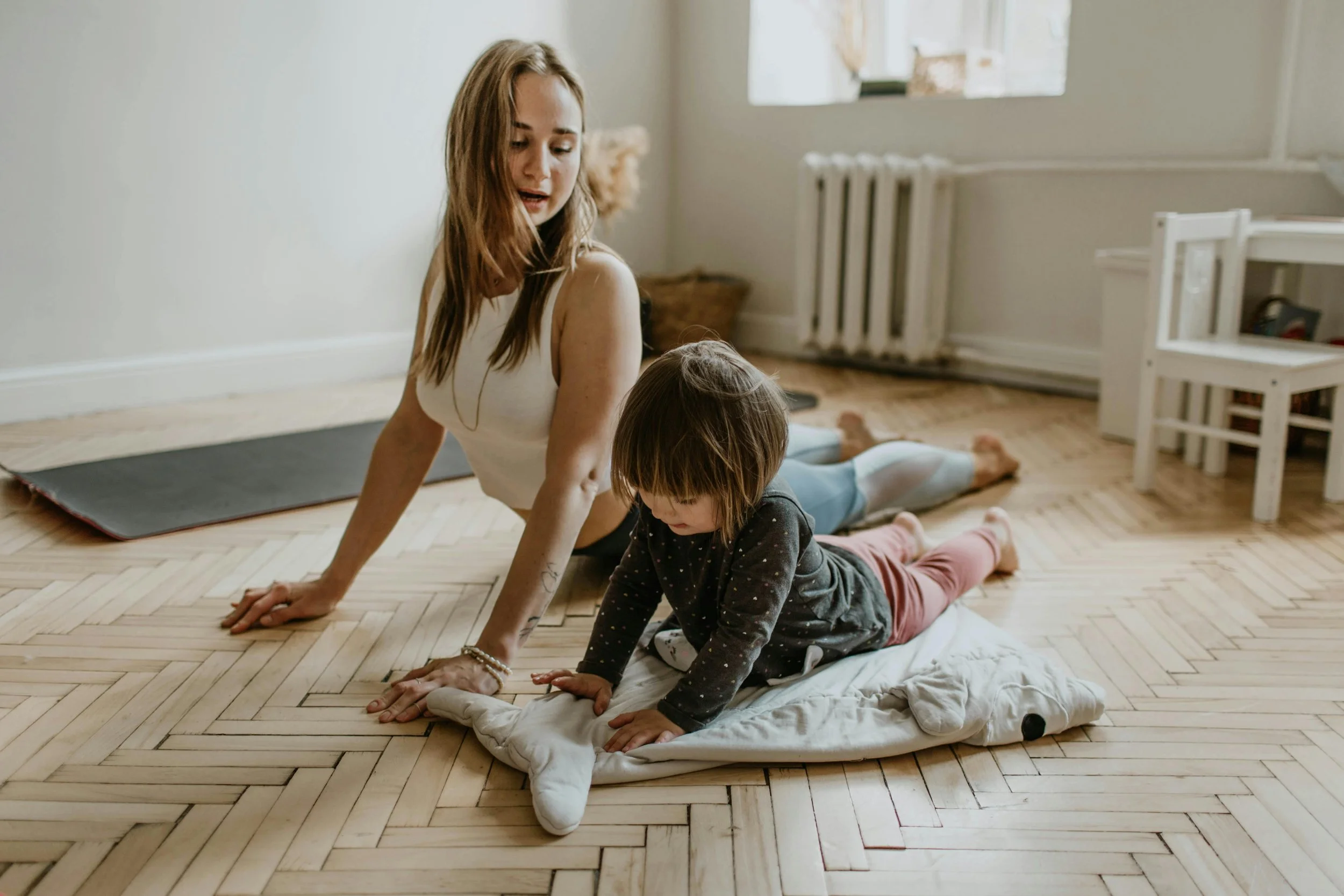 Woman while exercising with her young daughter.