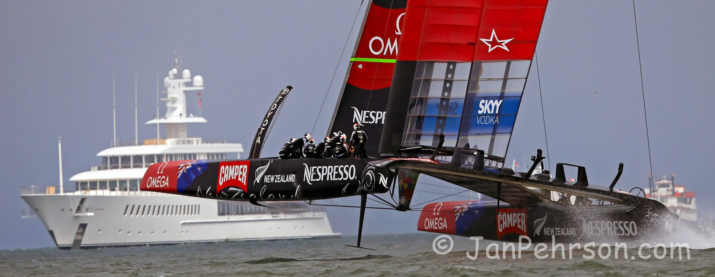 America's Cup Sept 8, 2013 San Francisco - Team New Zealand foils to weather past Larry Ellison's superyacht Musashi during the America's Cup on San Francisco Bay.