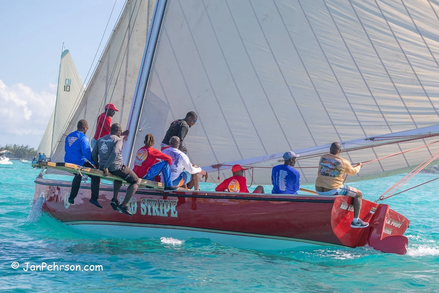 April 2023, George Town, Bahamas, National Family Island Regatta, A-Class, Red Stripe, from Black Point, Exuma