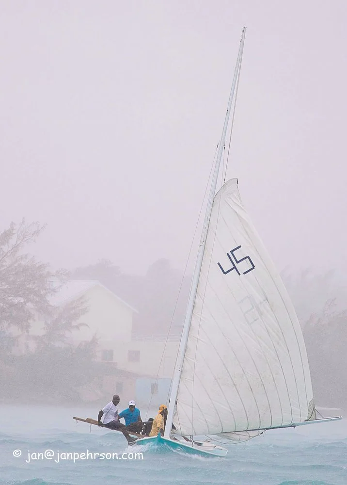 April 2019, George Town, Exuma, Bahamas, C-Class Sloop "Keep your Eyes On Him" sails through a rain squall