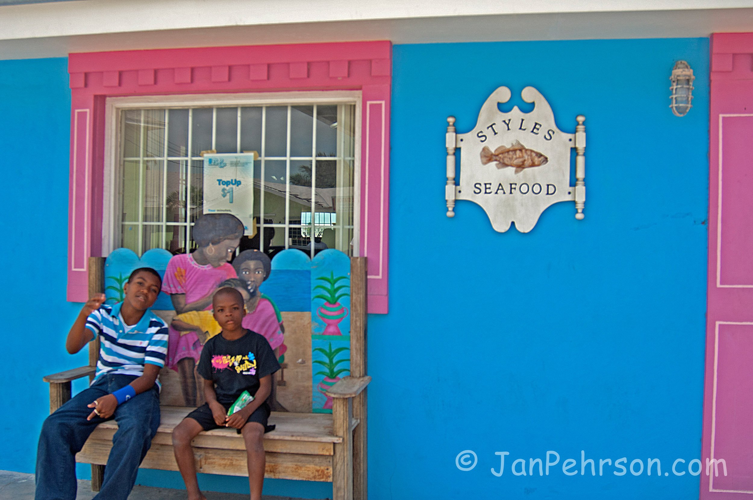 National Family Island Regatta of the Bahamas 2014 -  kids on bench in front of seafood store (0056)