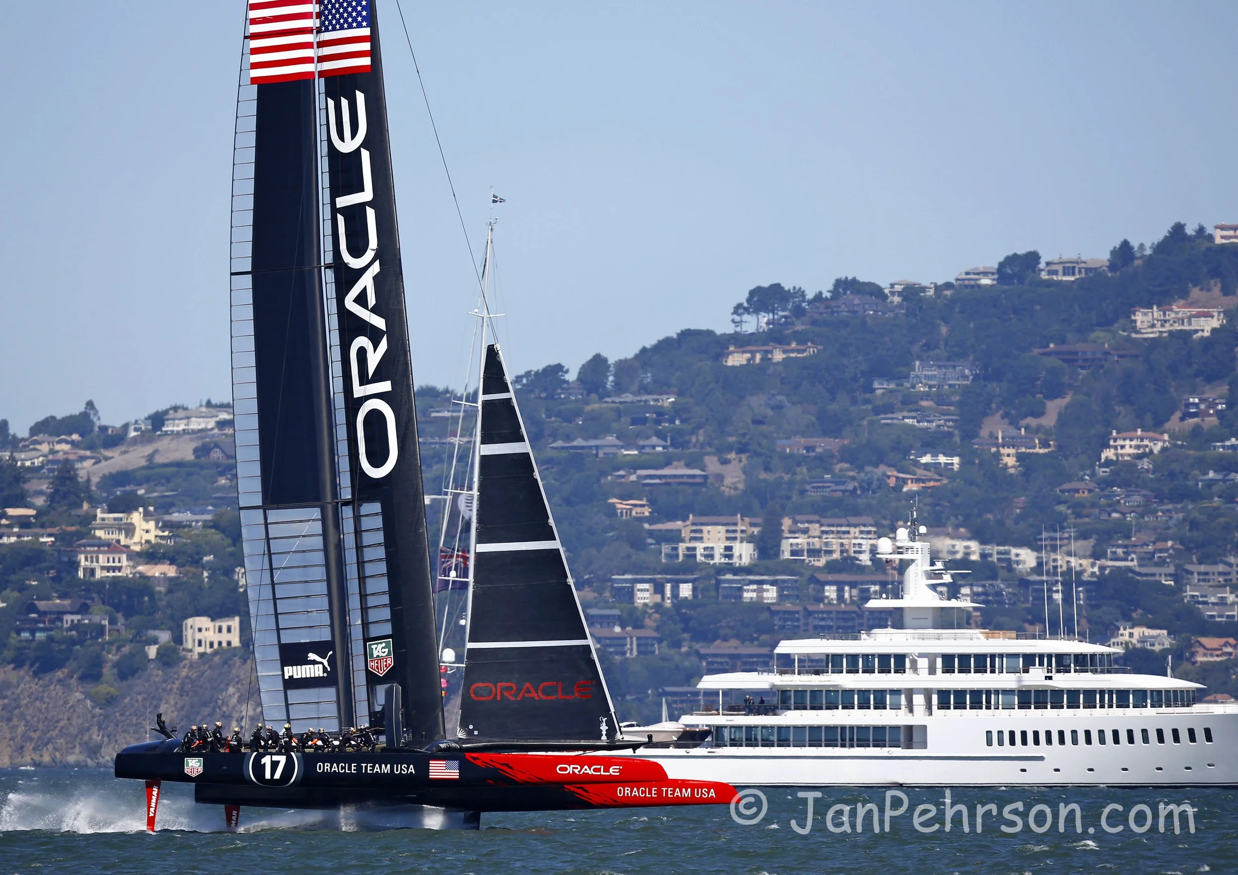 America's Cup Sept 15, 2013 San Francisco  Race 9. Team USA (Oracle) foils past Larry Ellison's superyacht Musashi during the America's Cup on San Francisco Bay (0230)