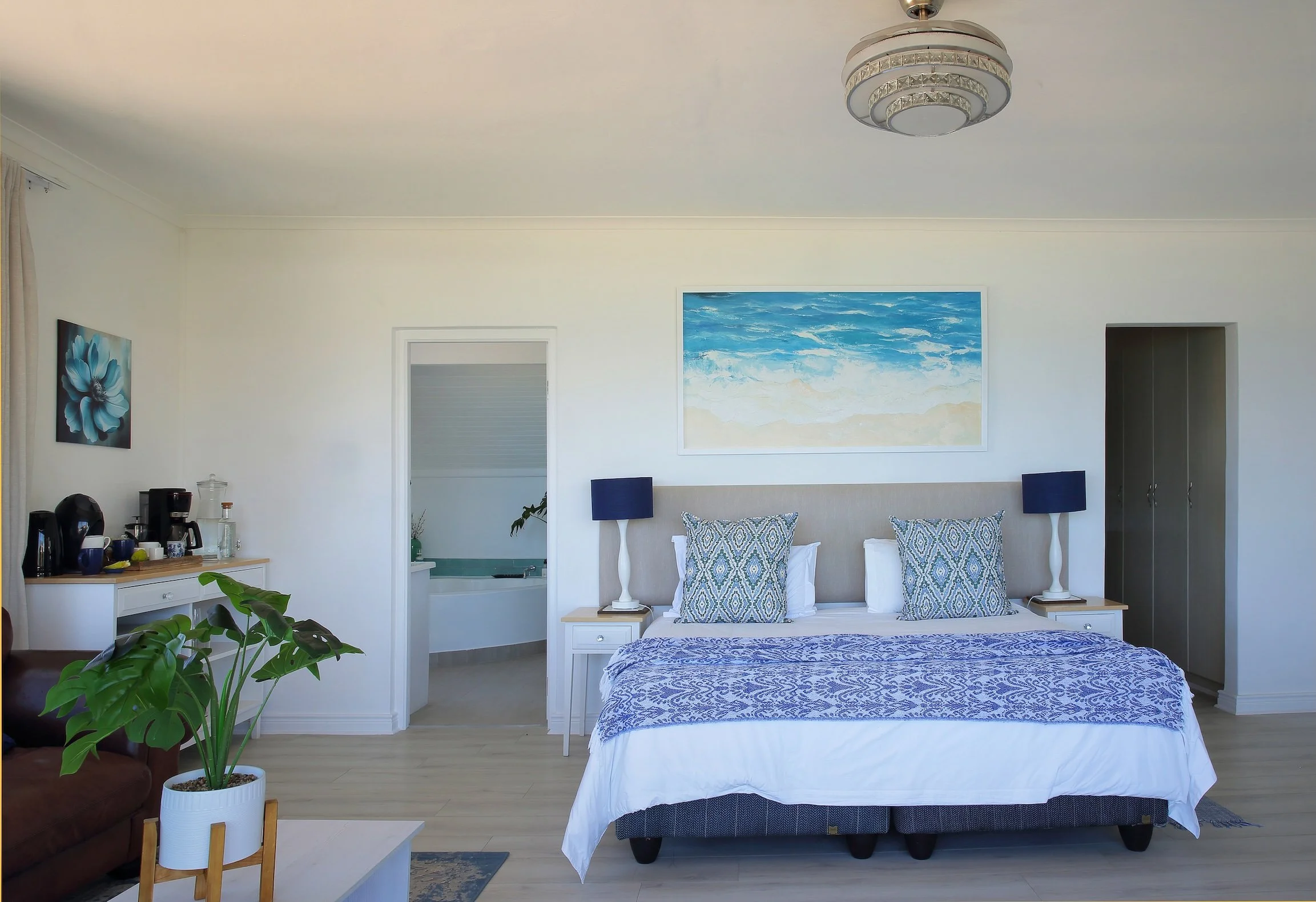 Spacious ocean-view bedroom with king bed, coastal decor and en-suite bathroom at Mykonos Guest House.