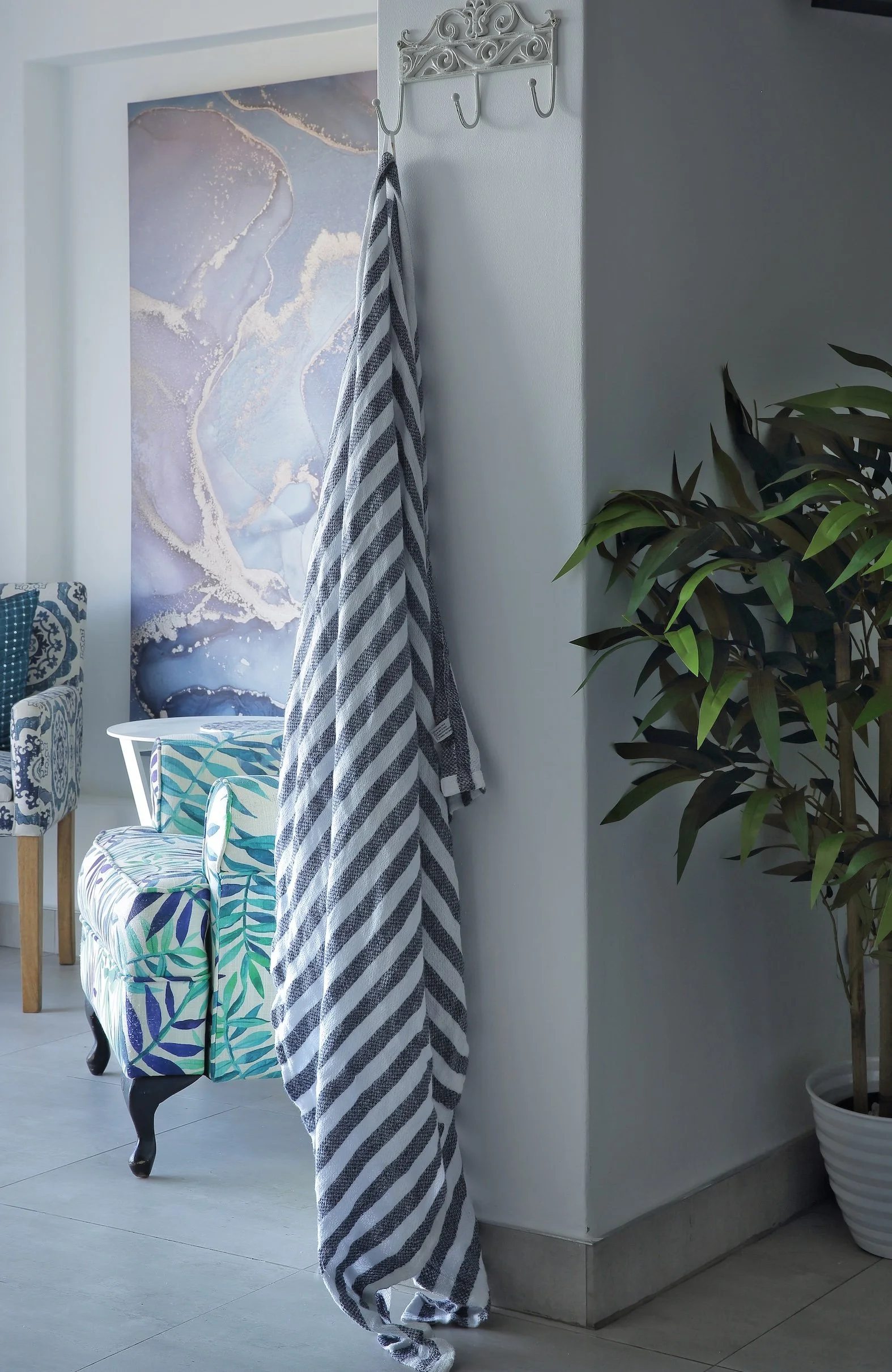 Coastal lounge chair and interior detail in upper deck sea-facing room at Mykonos Luxury Guest House.