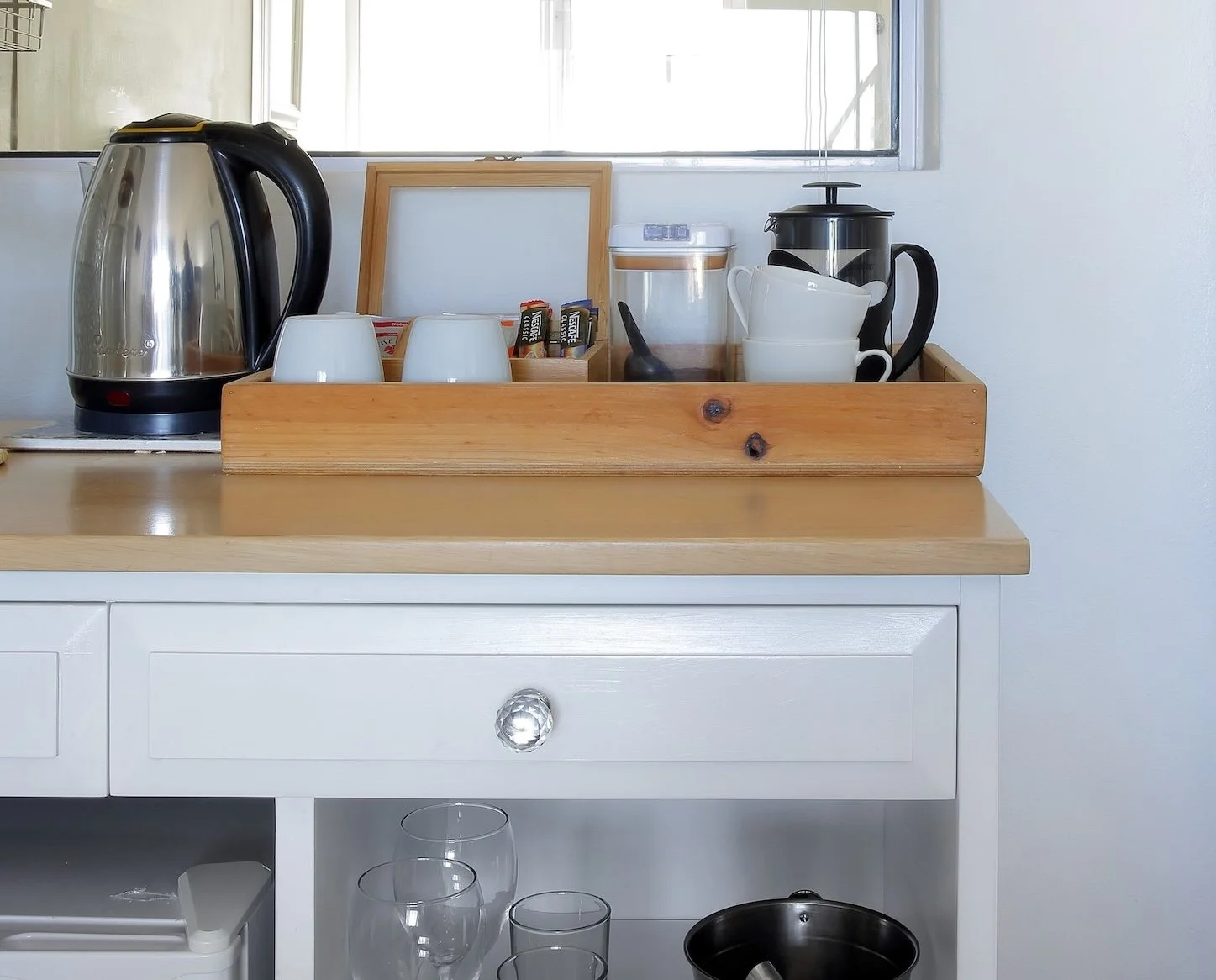 In-room tea and coffee station with kettle, French press and mini fridge in luxury guest room at Mykonos St Francis Bay.