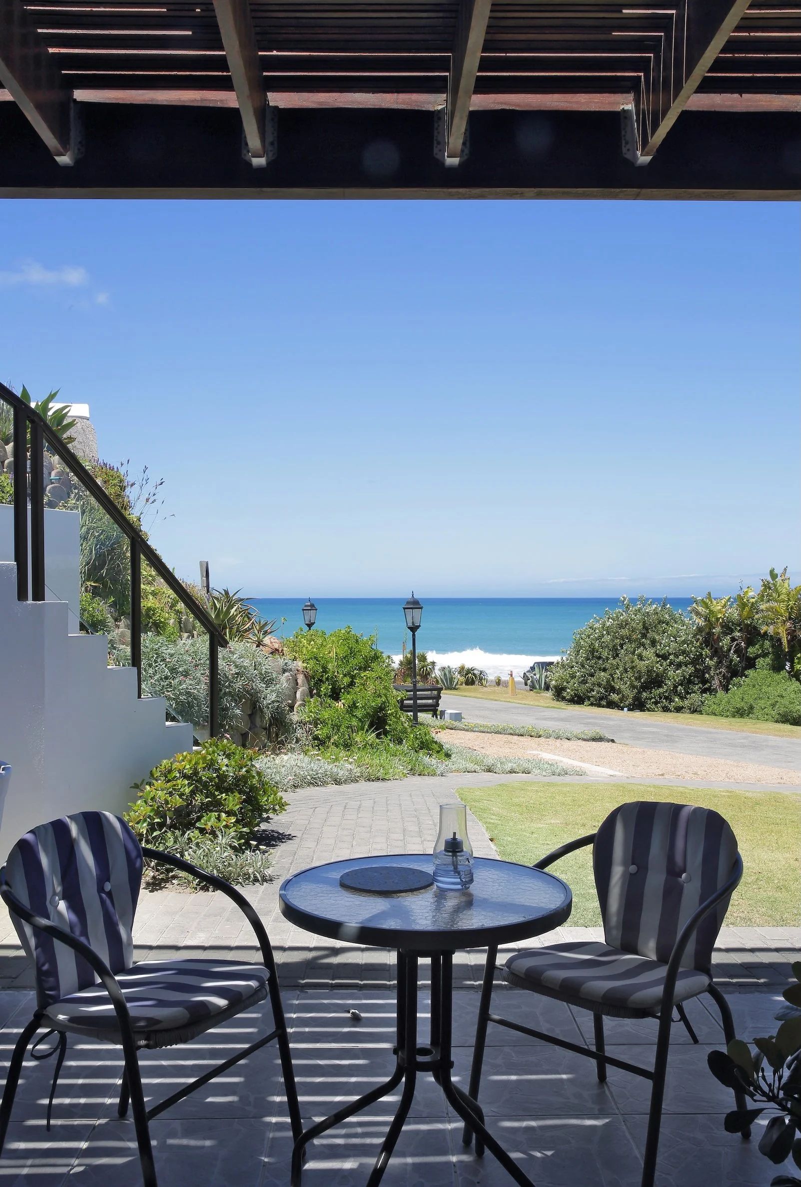 Private patio with outdoor seating and ocean views from upper-deck room at Mykonos Luxury Guest House in St Francis Bay.