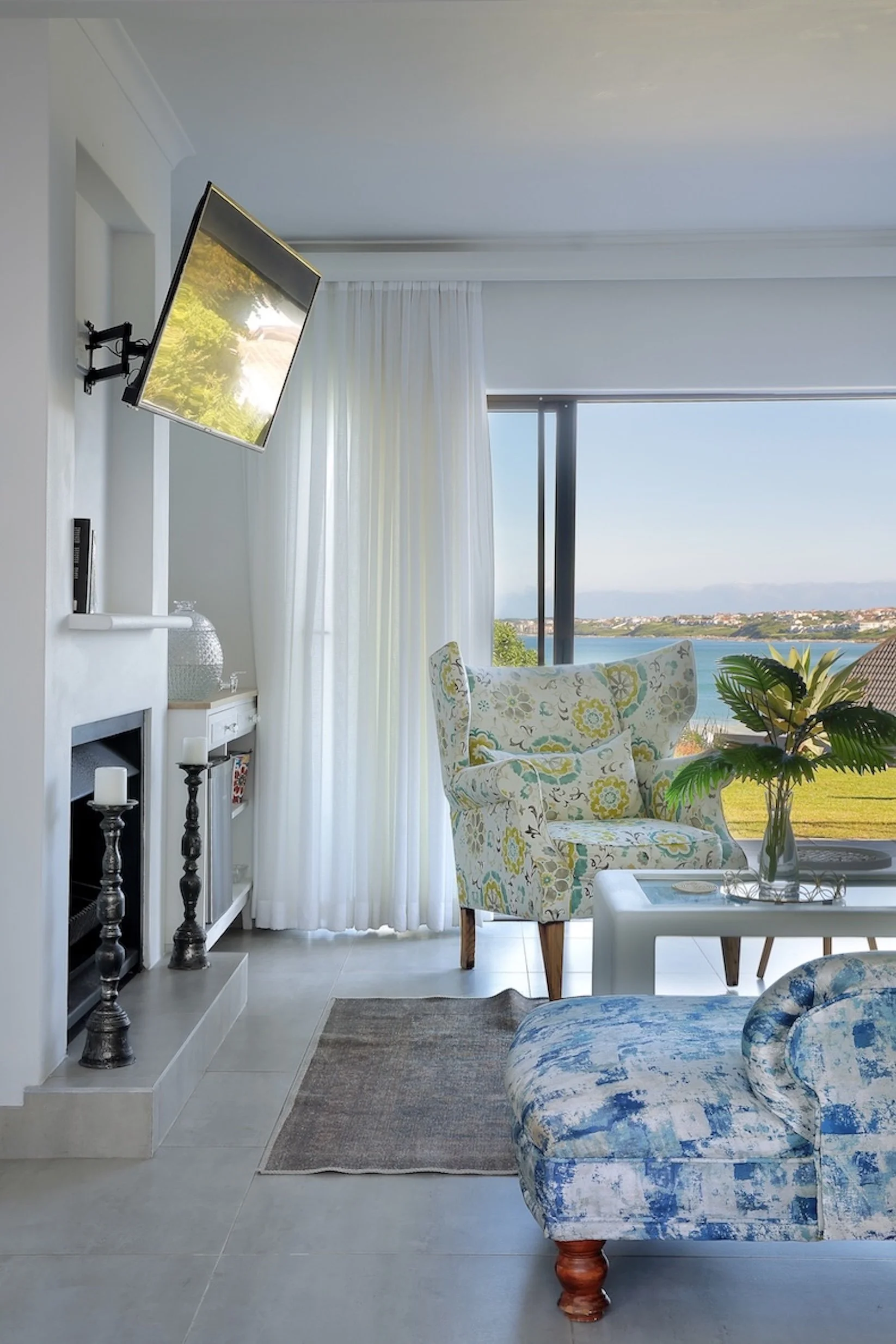 Indoor lounge with fireplace and ocean views in deluxe sea-facing room at Mykonos Luxury Guest House.