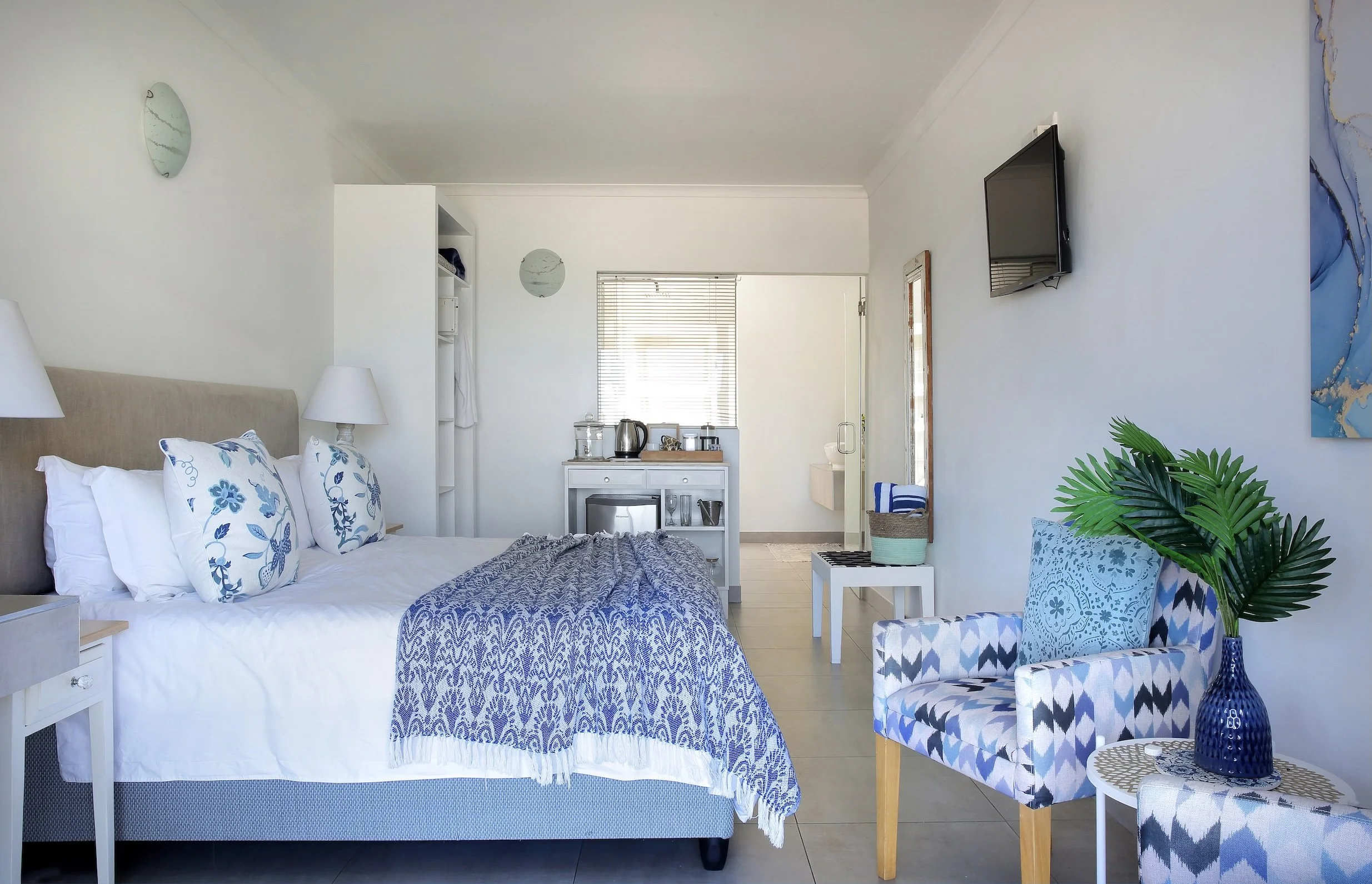 Spacious sea-facing ground floor bedroom with king bed and lounge seating at Mykonos Luxury Guest House in St Francis Bay.