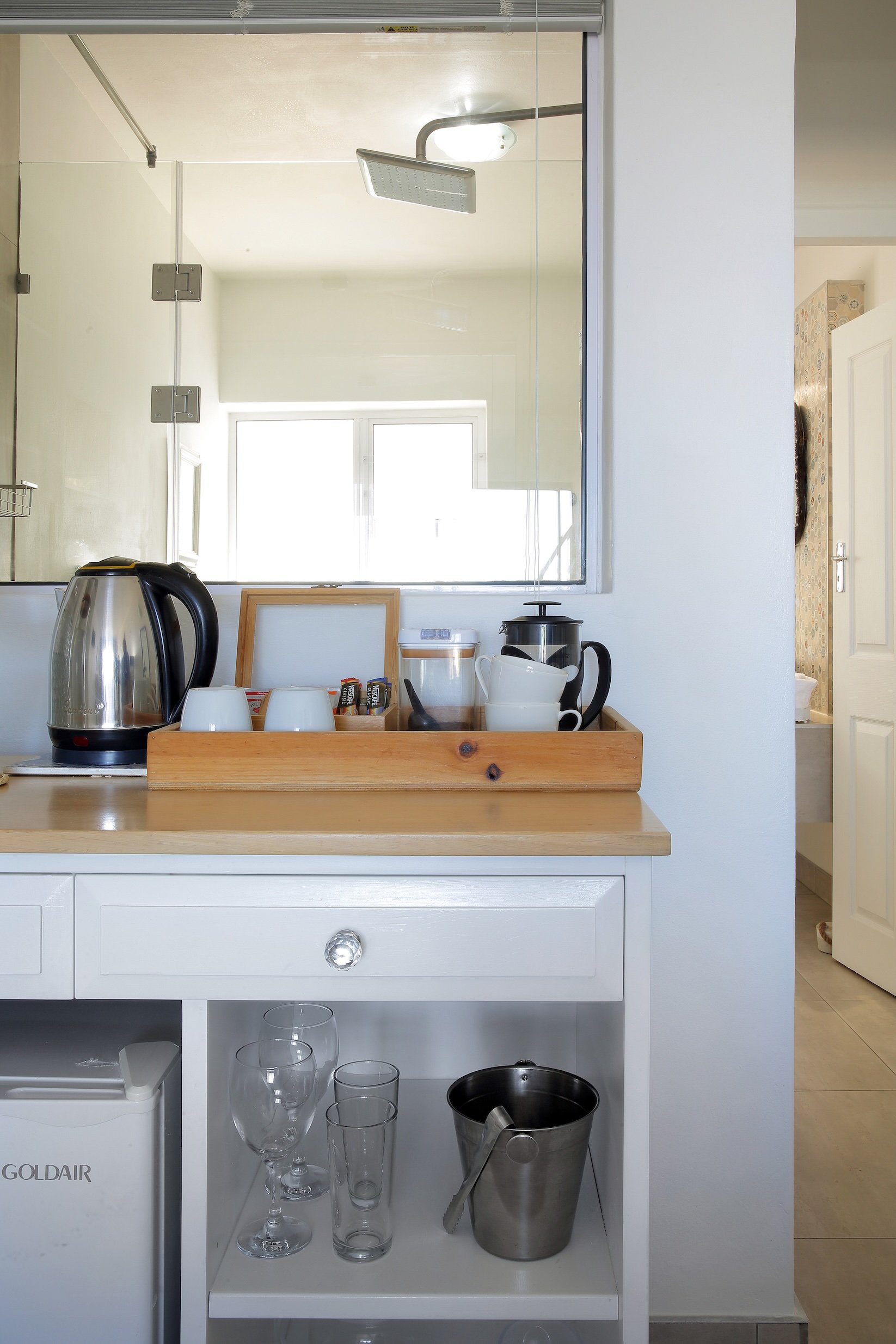In-room tea and coffee station with kettle, French press and mini fridge in luxury guest room at Mykonos St Francis Bay.