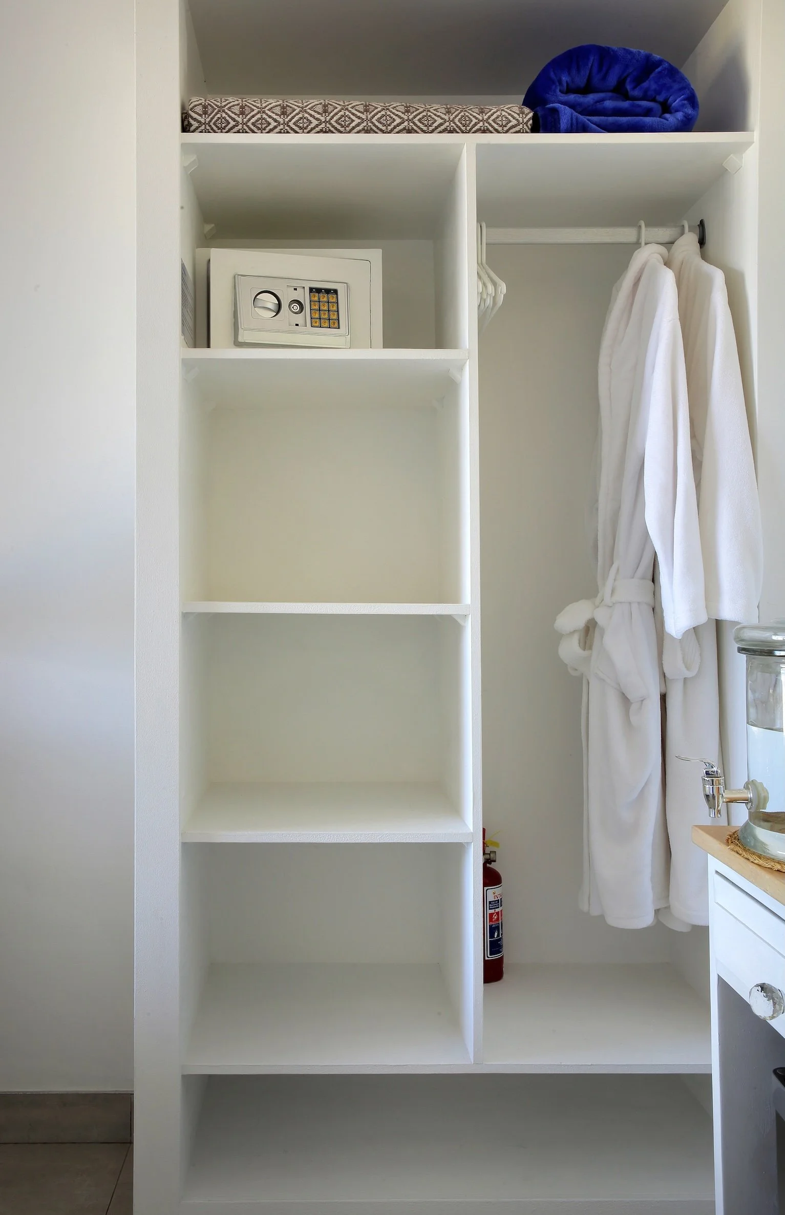 Open wardrobe and shelving storage in sea-facing ground floor room at Mykonos Luxury Guest House, St Francis Bay.
