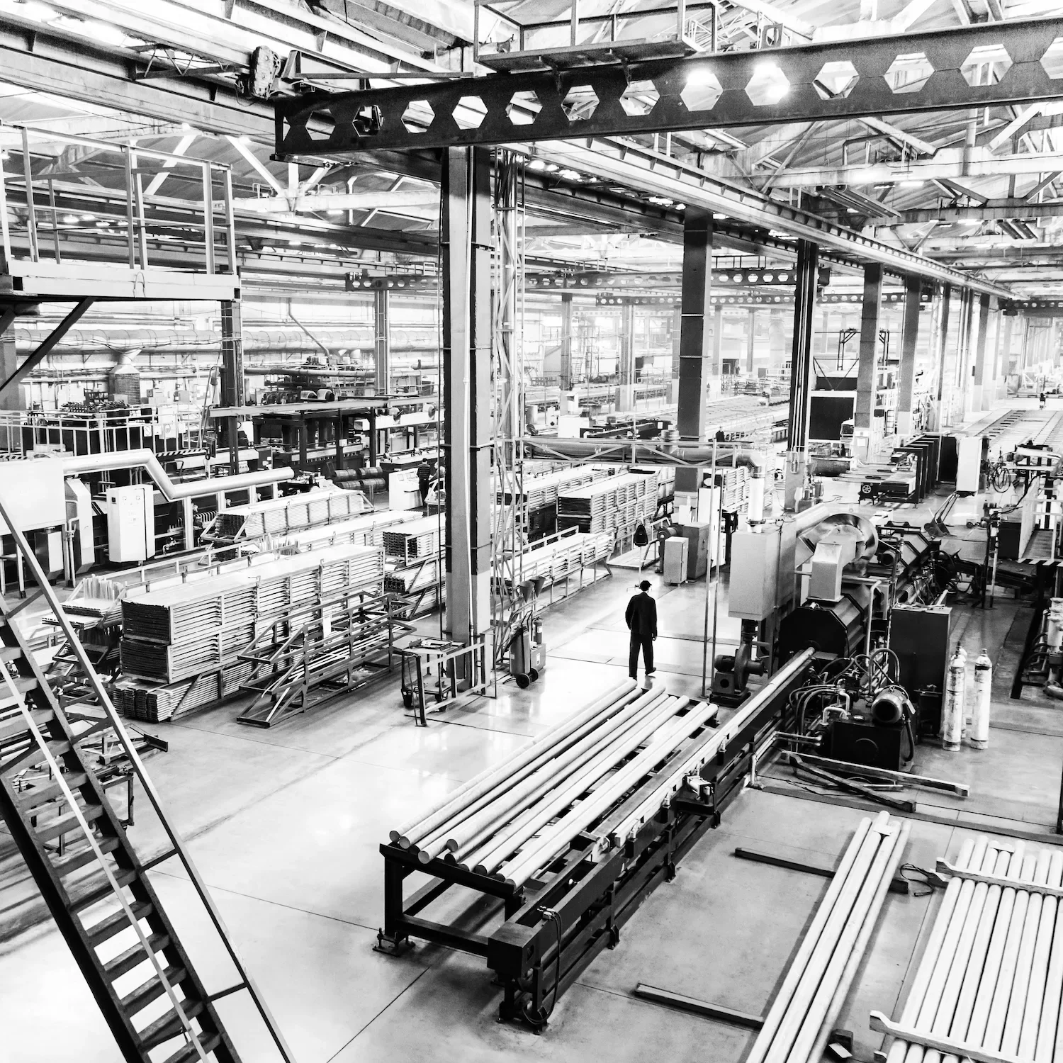 Wide angle interior of large factory floor with lone figure representing leadership coaching in Birmingham