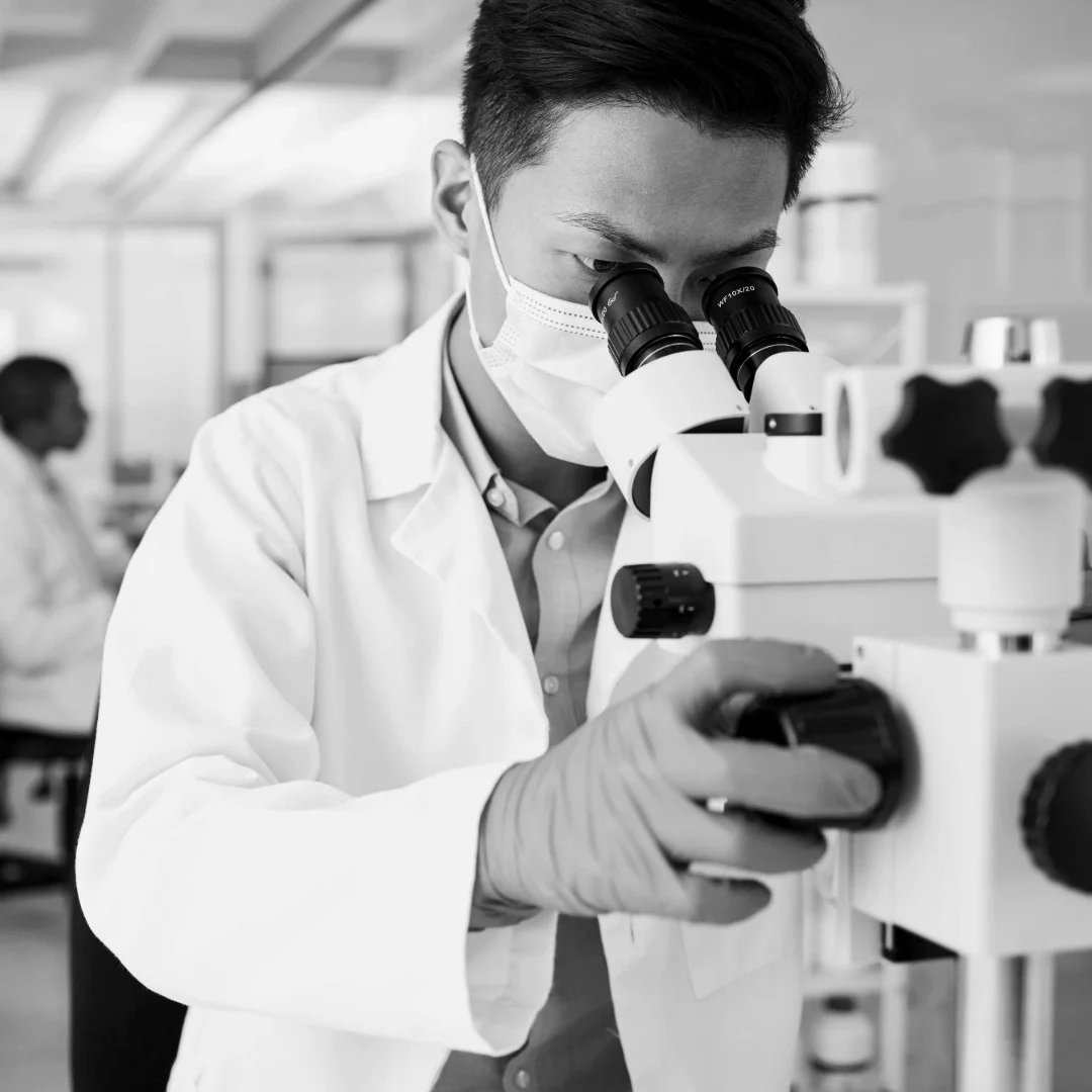 Scientist adjusting laboratory equipment, representing executive coaching for pharma and life sciences leaders