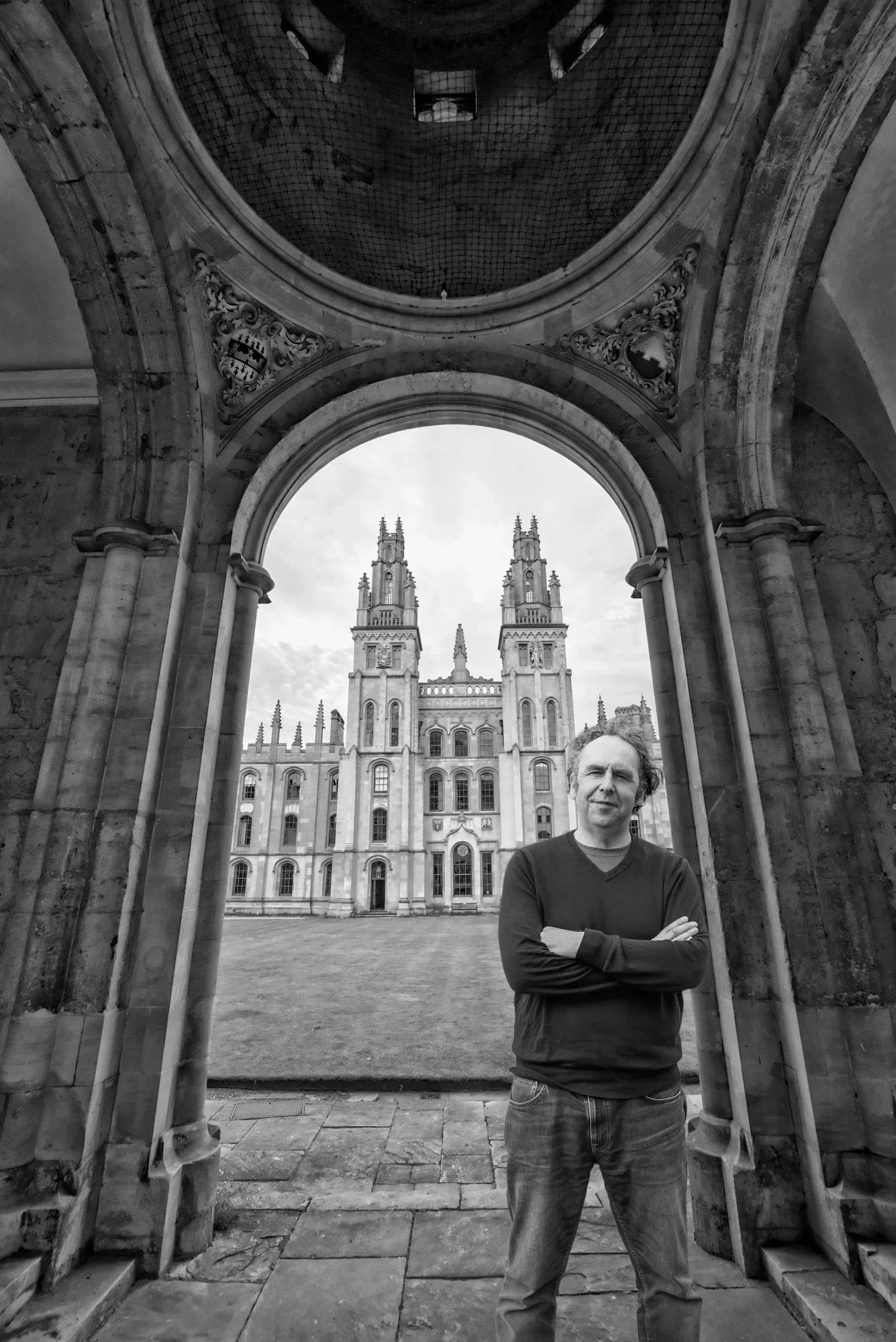 Leadership coach John Dyson standing beneath the arch at All Souls College Oxford