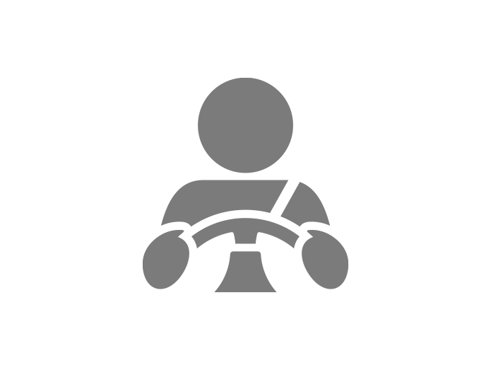 Icon of a person sitting at a steering wheel, representing driving or transportation.