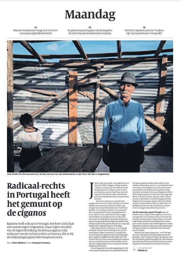 Capa de jornal com uma foto de dois idosos em uma estrutura de madeira e metal ao ar livre, sob luz solar.