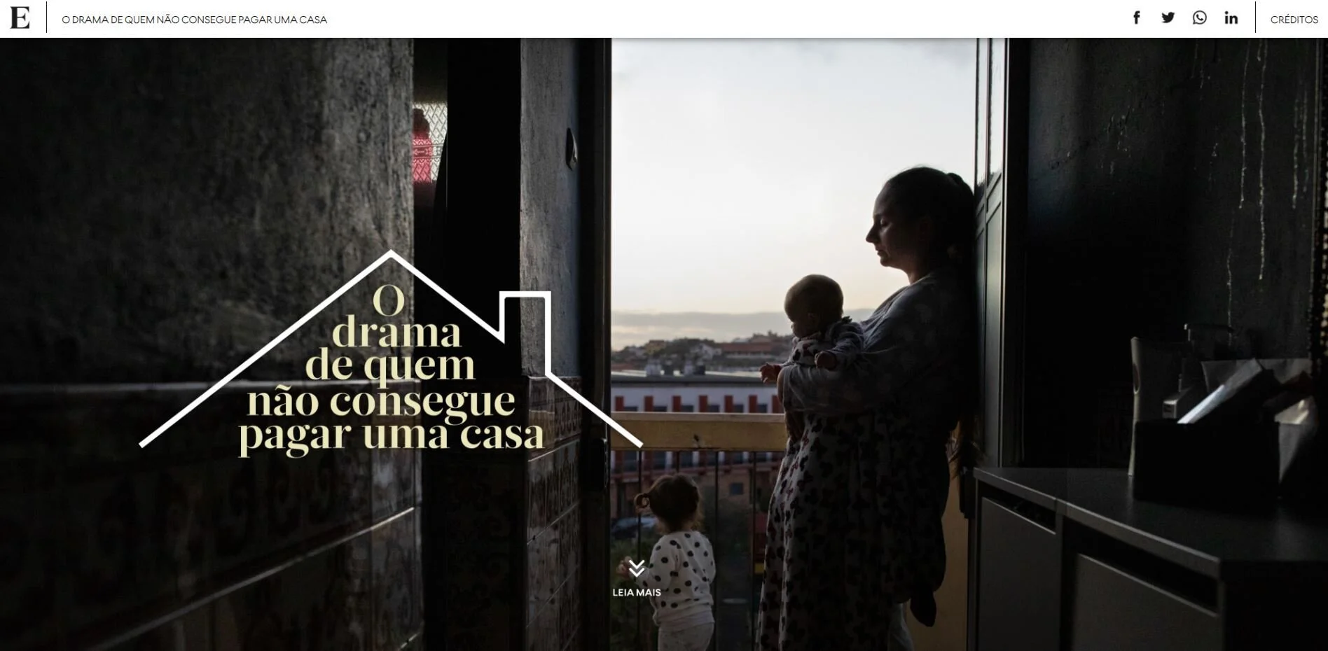 Mulher segurando uma criança pequena ao lado de uma janela com uma vista de uma cidade ao entardecer, com outra criança pequena na porta, em um ambiente interno com iluminação baixa.