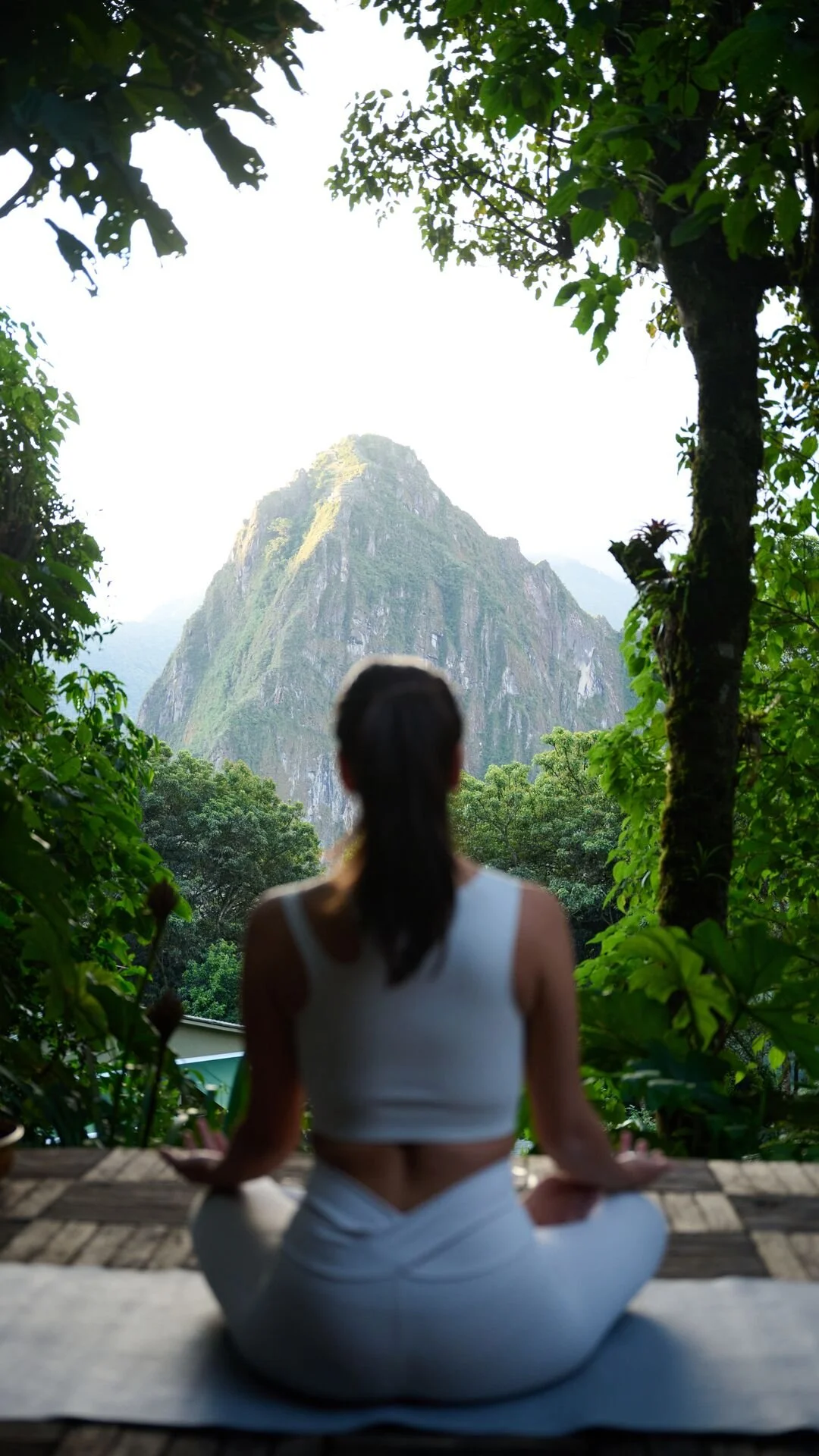 a woman in a yoga pose overlooking Matchu Pitchu