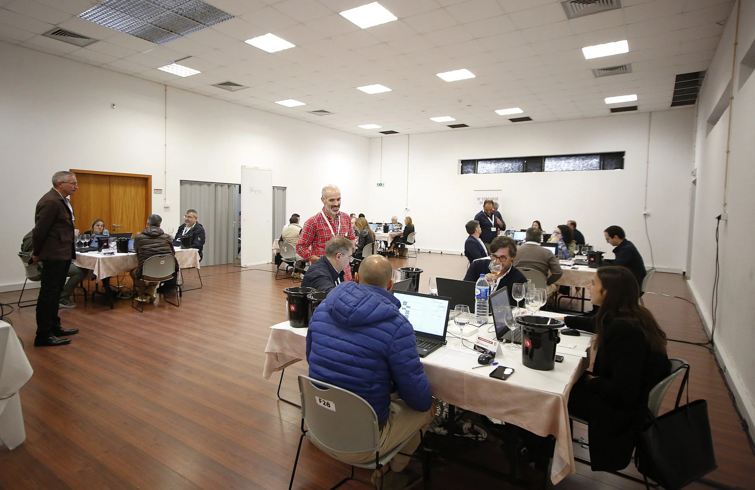 Reunião de negócios com pessoas usando laptops e conversando em um ambiente de sala de conferências grande e bem iluminada.