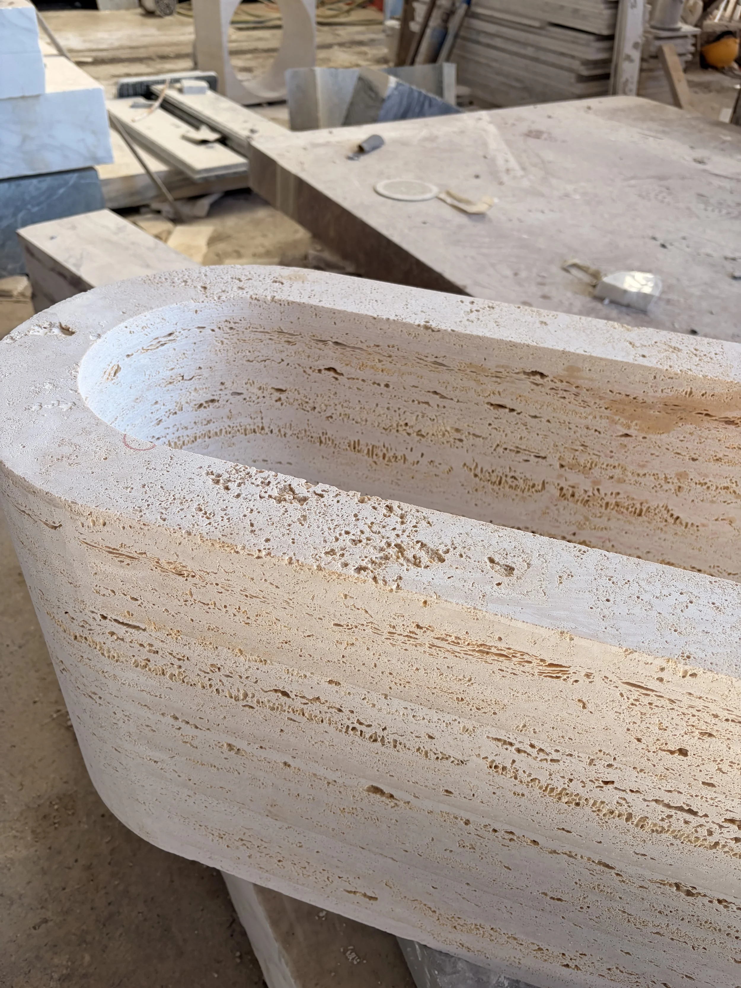 Travertine basin being carved during natural stone fabrication process