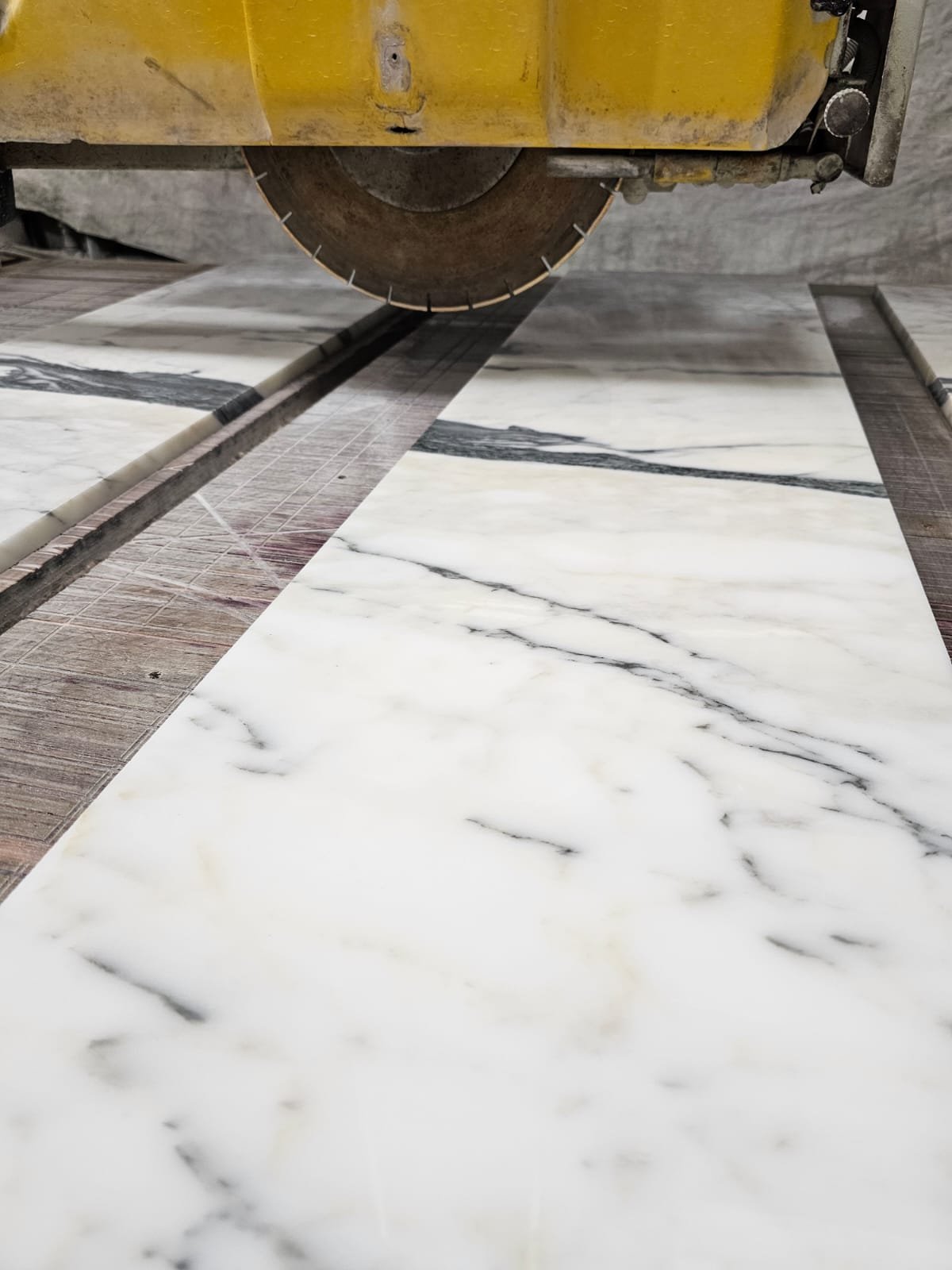 Marble slab being cut during fabrication process in natural stone production