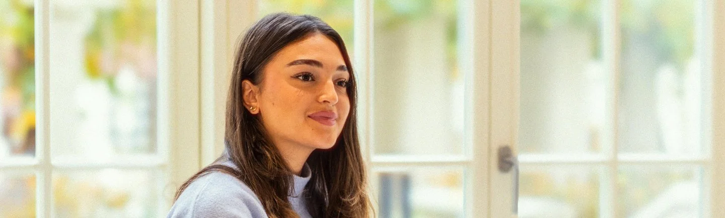 Lächelnde junge Frau im Wartebereich einer modernen und ästhetischen Zahnarztpraxis