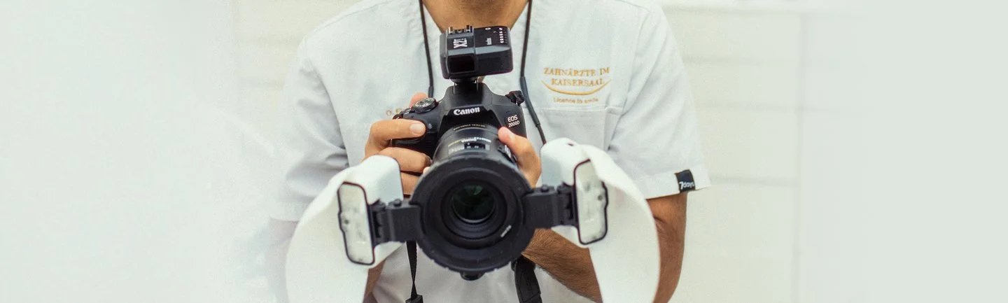 Zahnarzt in weißem Kittel fotografiert Zähne für die ästhetische Analyse in einer modernen Zahnarztpraxis. Dokumentation für Zahnästhetik und Behandlungsplanung.