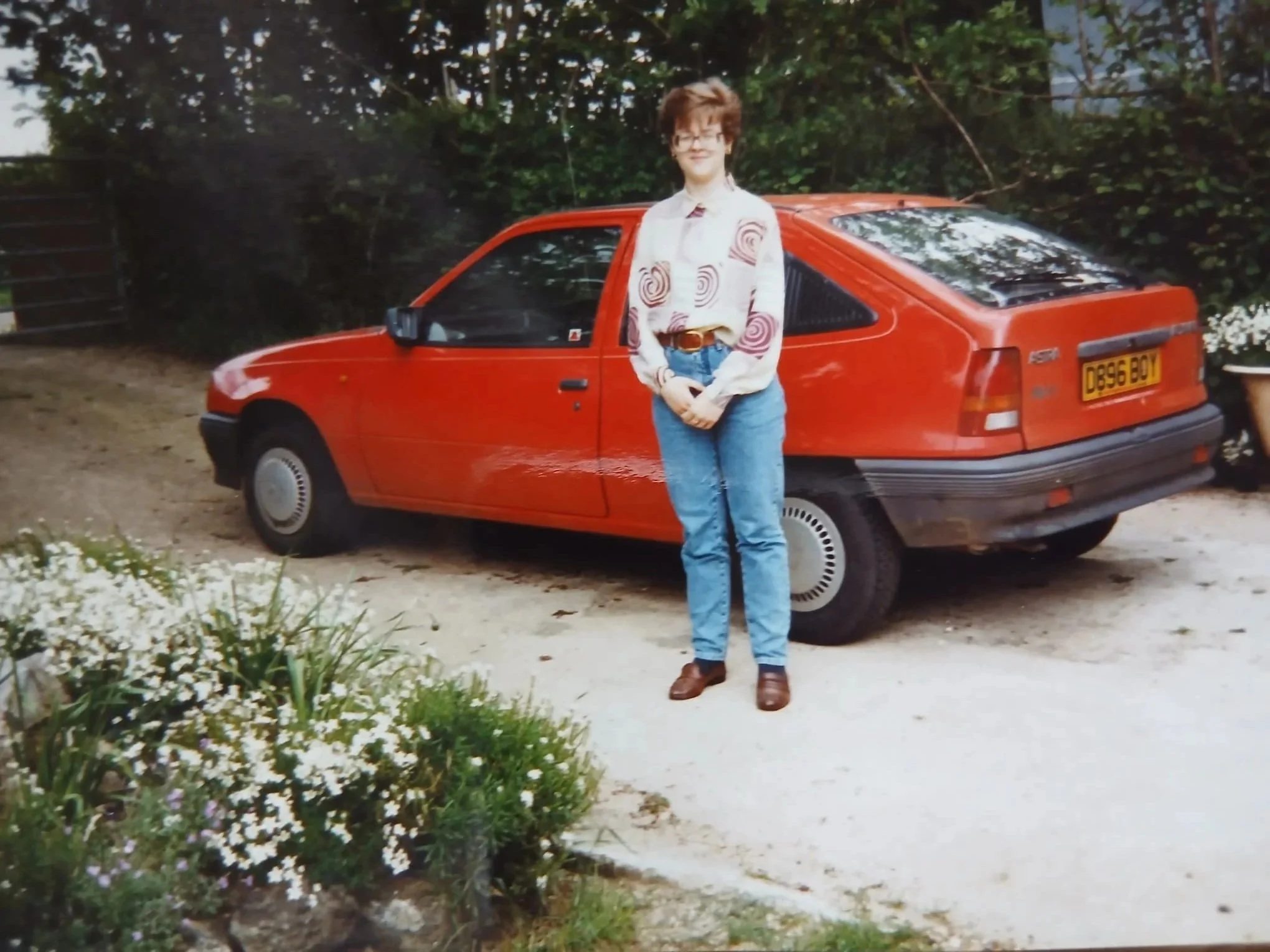 Helen aged around 20 with the first car she owned, bought and paid for herself.  A red Vauxhall Astra.