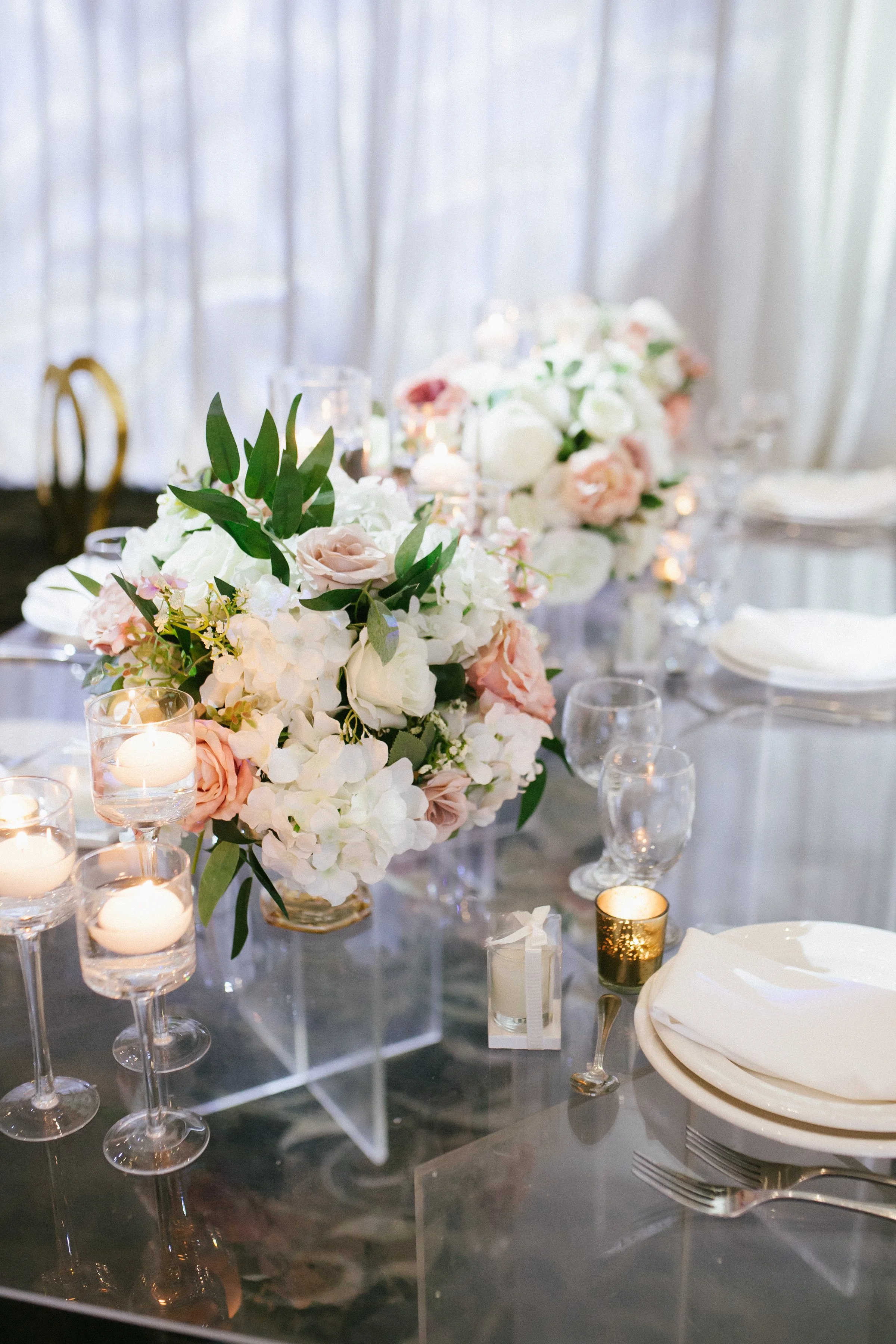 Elegant table setting with floral centerpiece, candles, and place settings at a formal event.