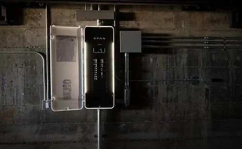 Electrical panel and wiring mounted on a brick wall.