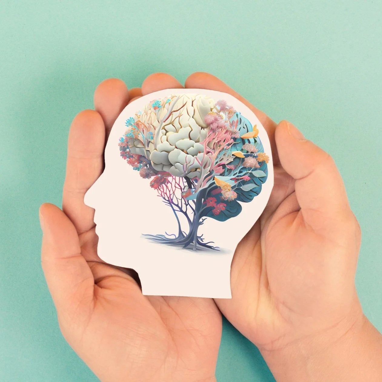 A person holding a sticker of a human head silhouette with a colorful tree inside it, representing the mind.