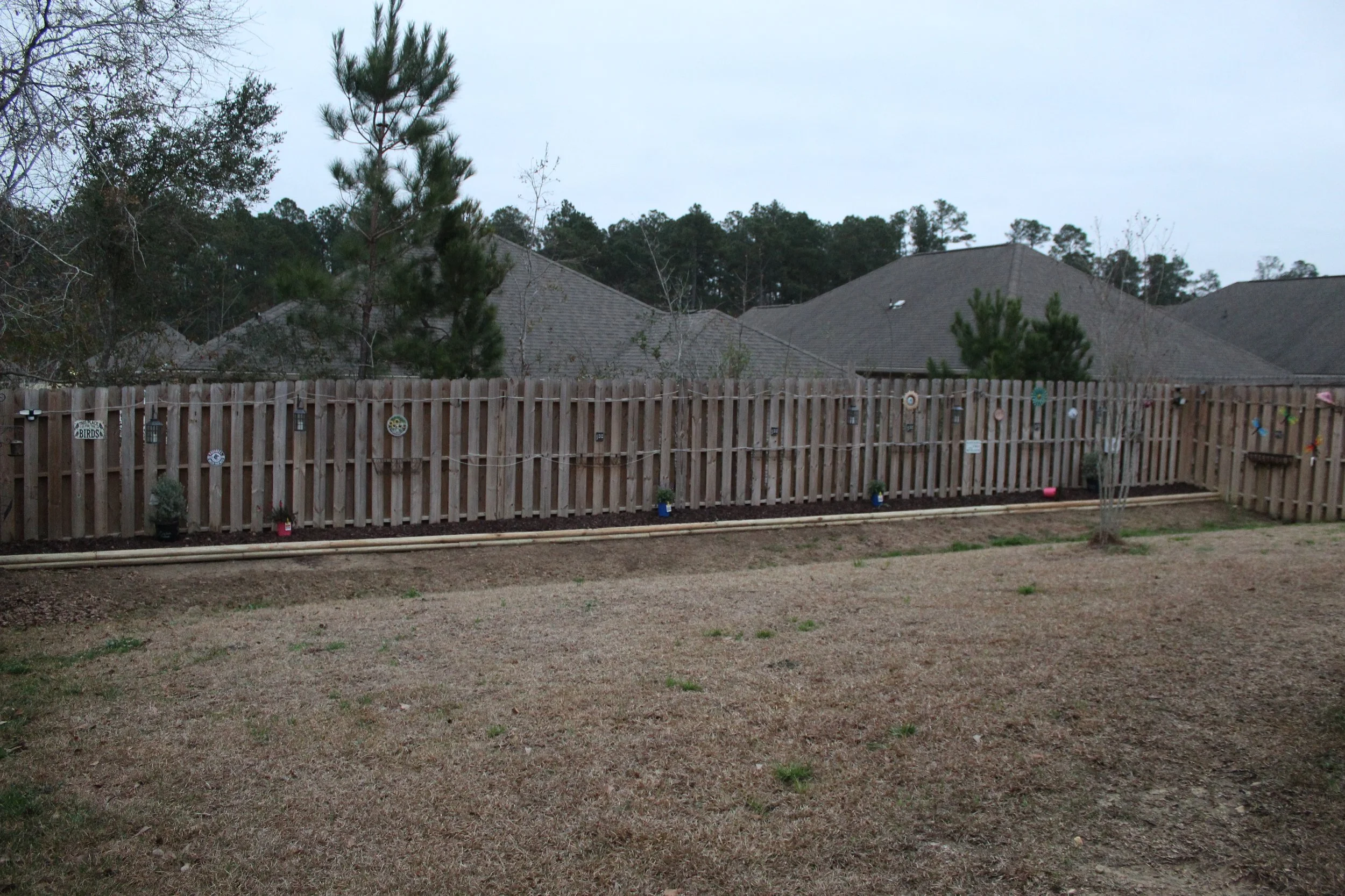 After flower bed and lawn care upgrade in Gulfport, MS by S.I. Lawn Care: clean, defined landscape and improved backyard.