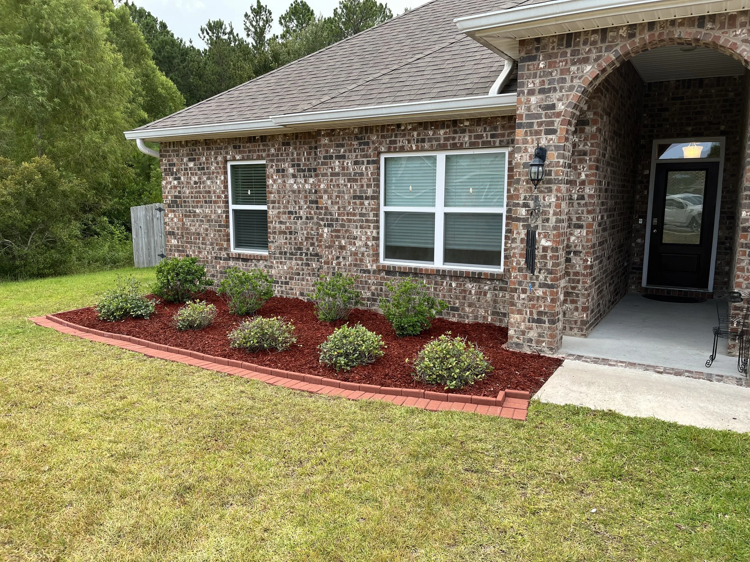 Professionally landscaped flower bed in front of a house in gulfport, Ms