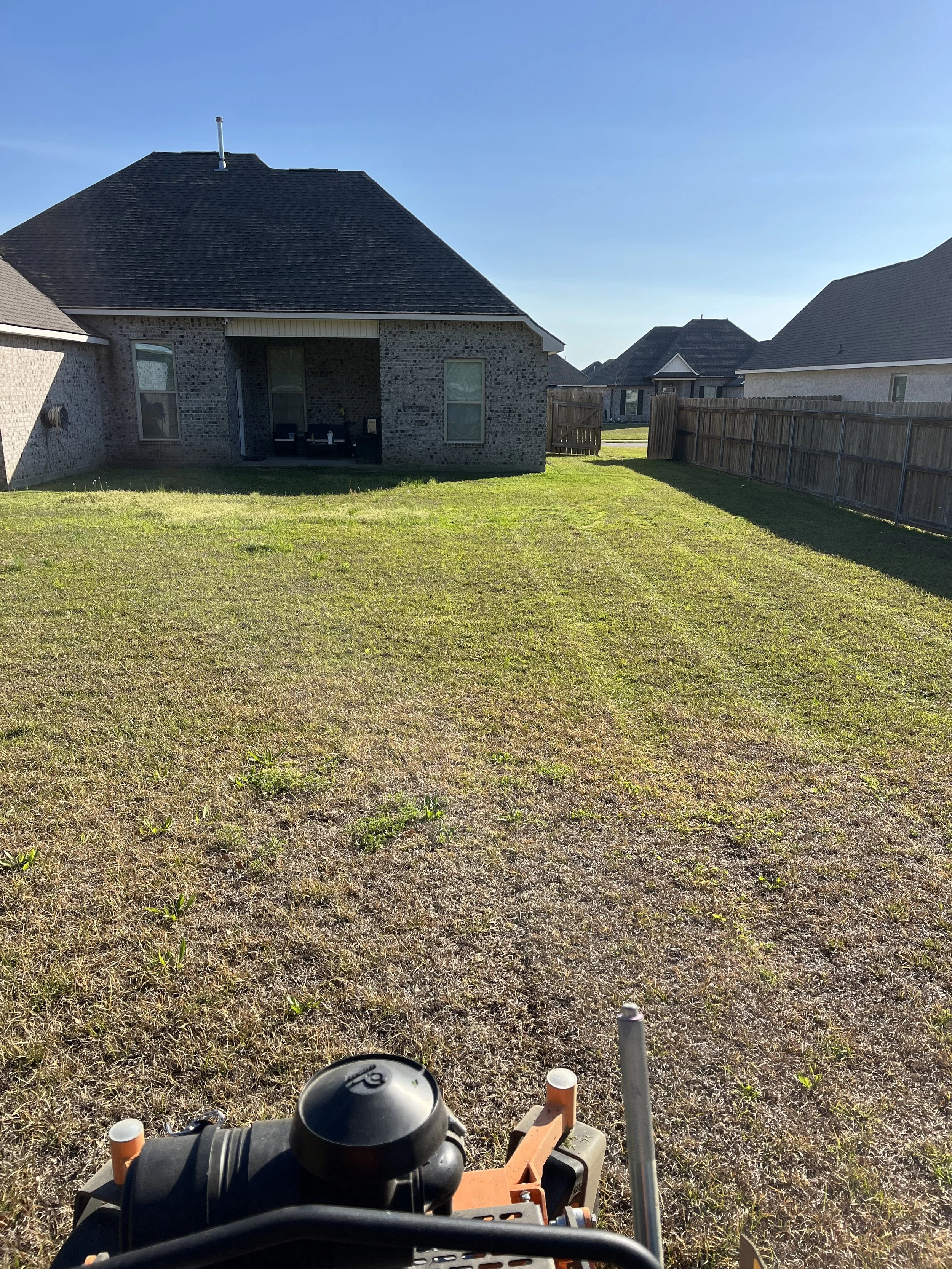 Residential lawn mowing service in Gulfport MS featuring a freshly maintained backyard with clean mowing lines and professional lawn care by S.I. Lawn Care.