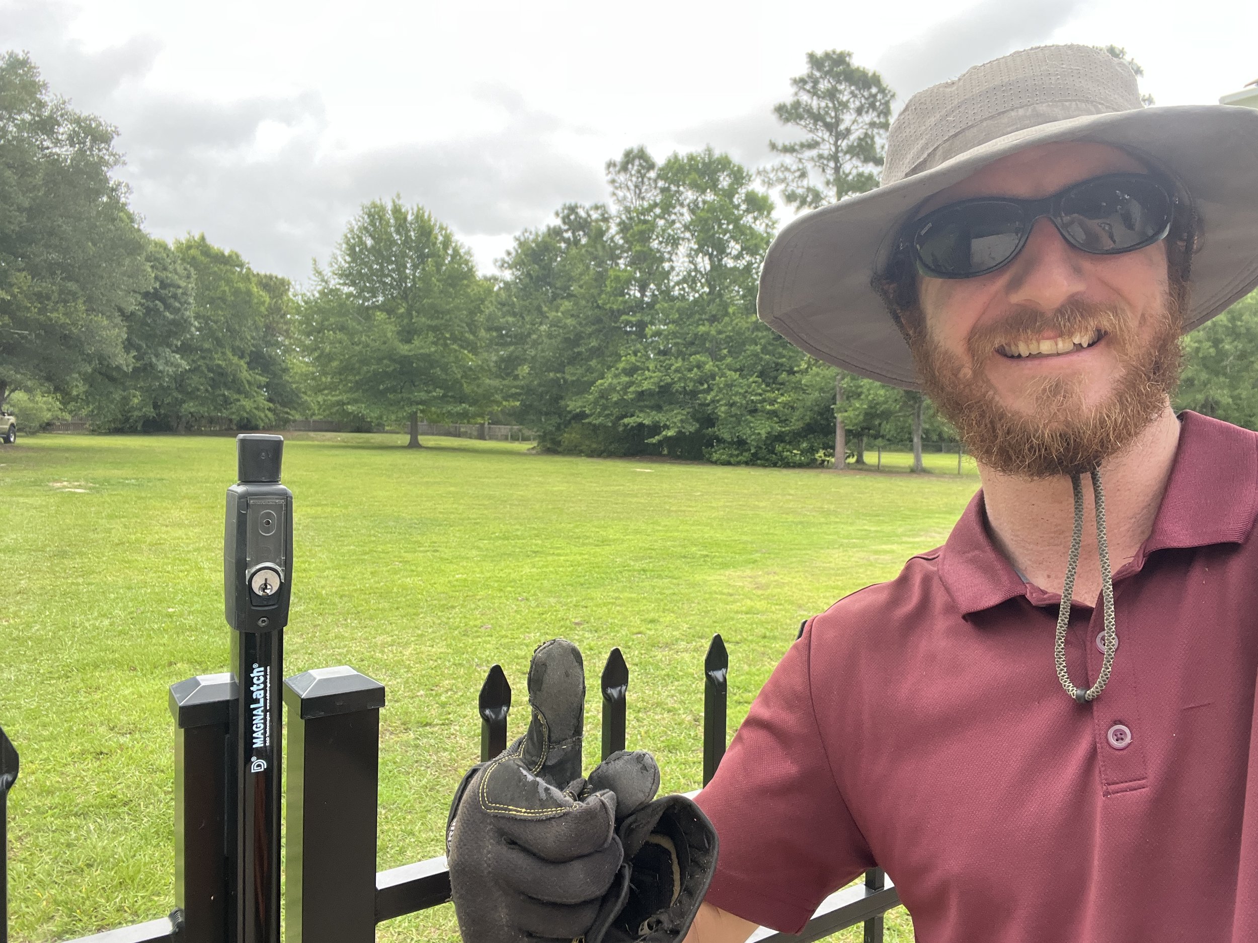 Professional lawn care specialist standing beside a freshly maintained yard in Gulfport MS with neatly mowed grass and clean landscaping by S.I. Lawn Care.