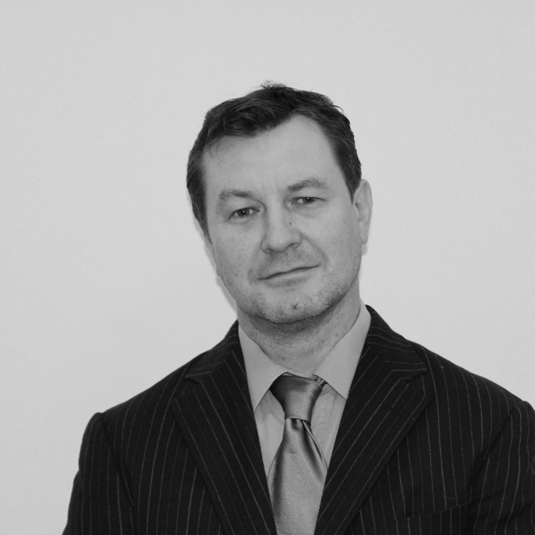 Black and white portrait of a man in a pinstripe suit and tie, with short dark hair, looking at the camera with a slight smile.
