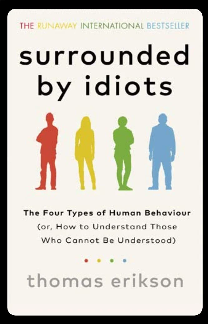 Book cover titled "Surrounded by idiots" by Thomas Erikson, featuring silhouettes of four people in red, yellow, green, and blue, representing the DISC behavioural colours, with the title and author and mentioning the four types of human behavior.