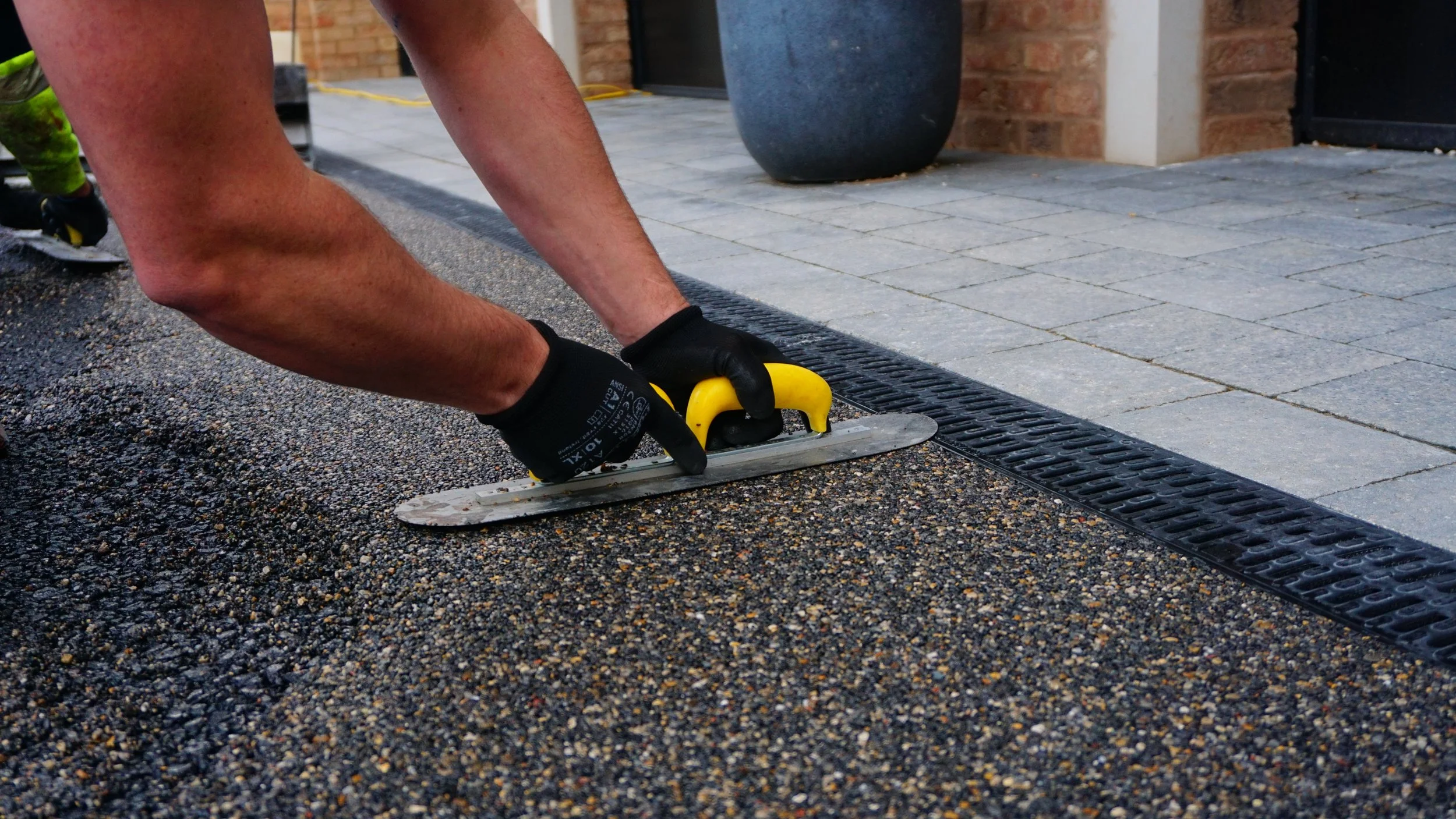 Professional troweling of stone surface during driveway installation