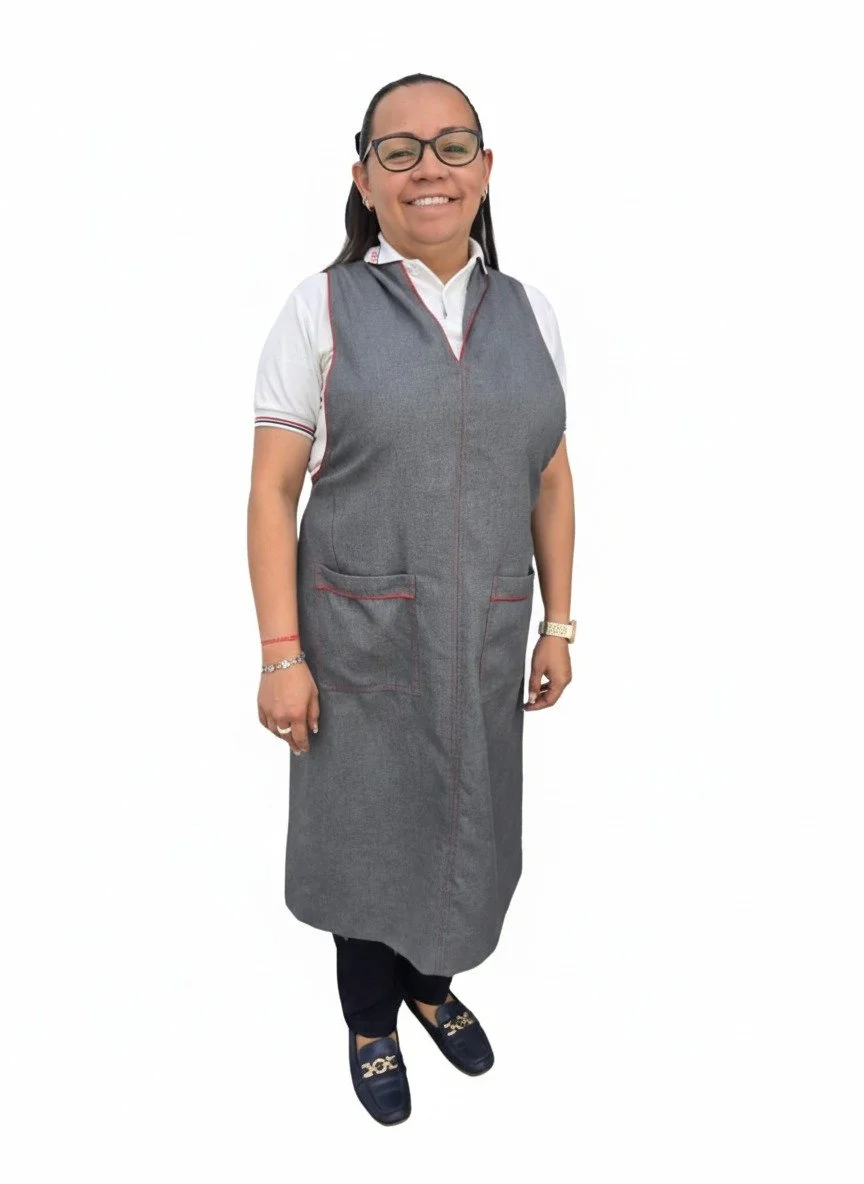 Mujer con gafas, sonrisa, ropa formal, vestido gris, camiseta blanca, zapatos oscuros, fondo blanco