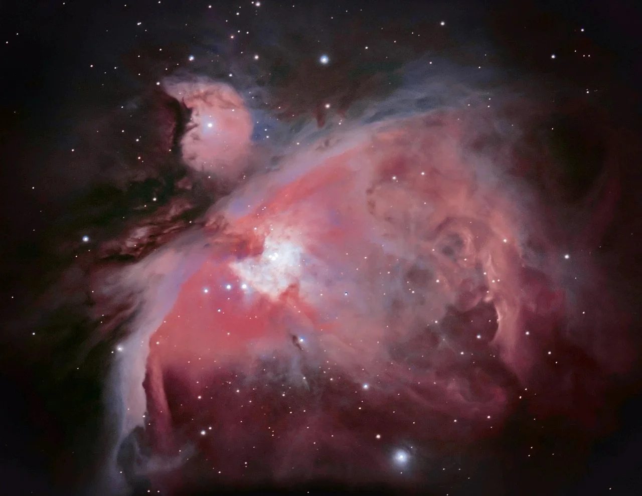 A detailed image of the orion nebula in shades of pink, purple, and white.